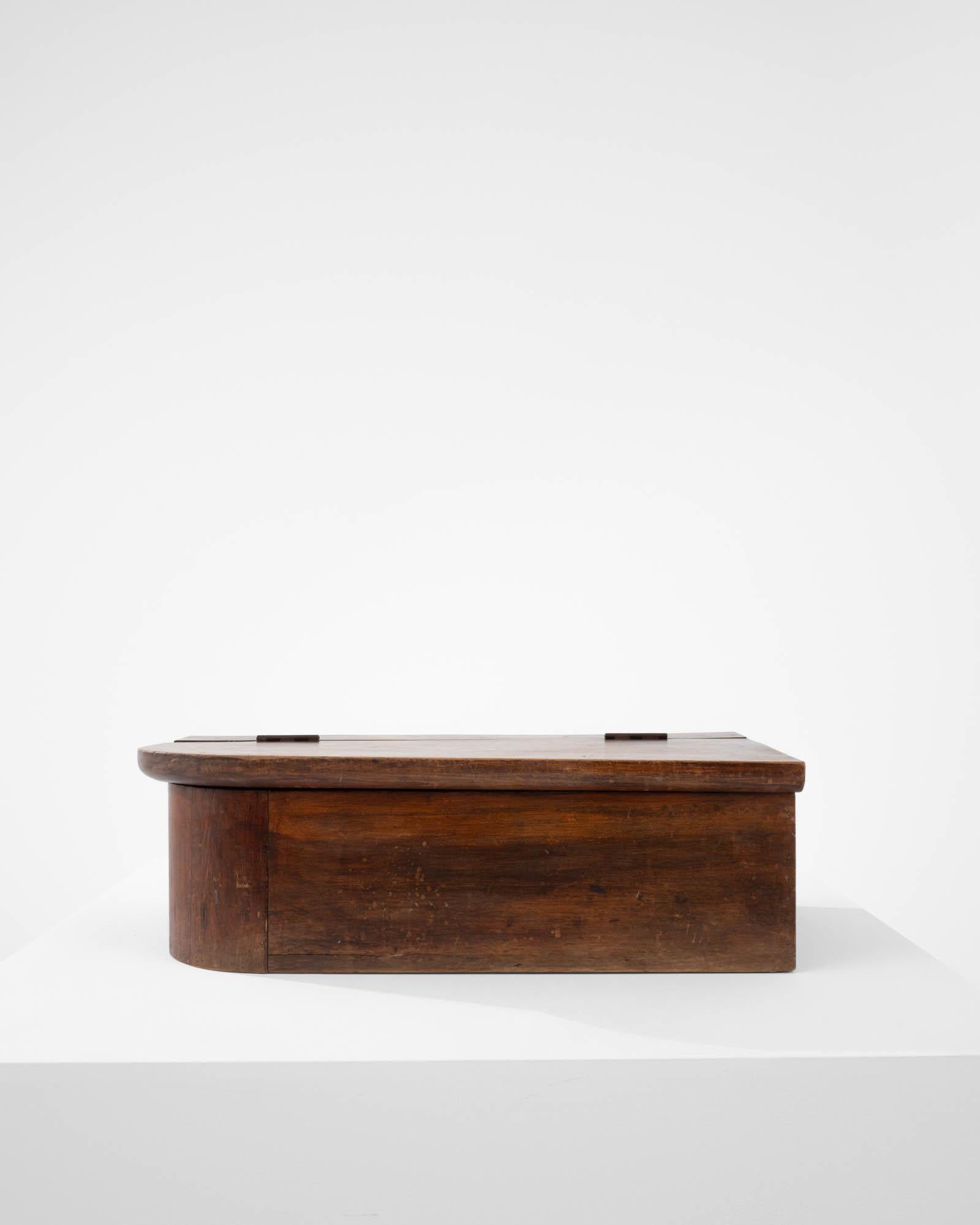 Fabriquée à la main en France au XIXe siècle, cette charmante boîte en bois présente un design unique avec un coin arrondi, ce qui lui confère une allure asymétrique captivante. L'ajout d'un élégant couvercle rabattable garantit un accès sans effort
