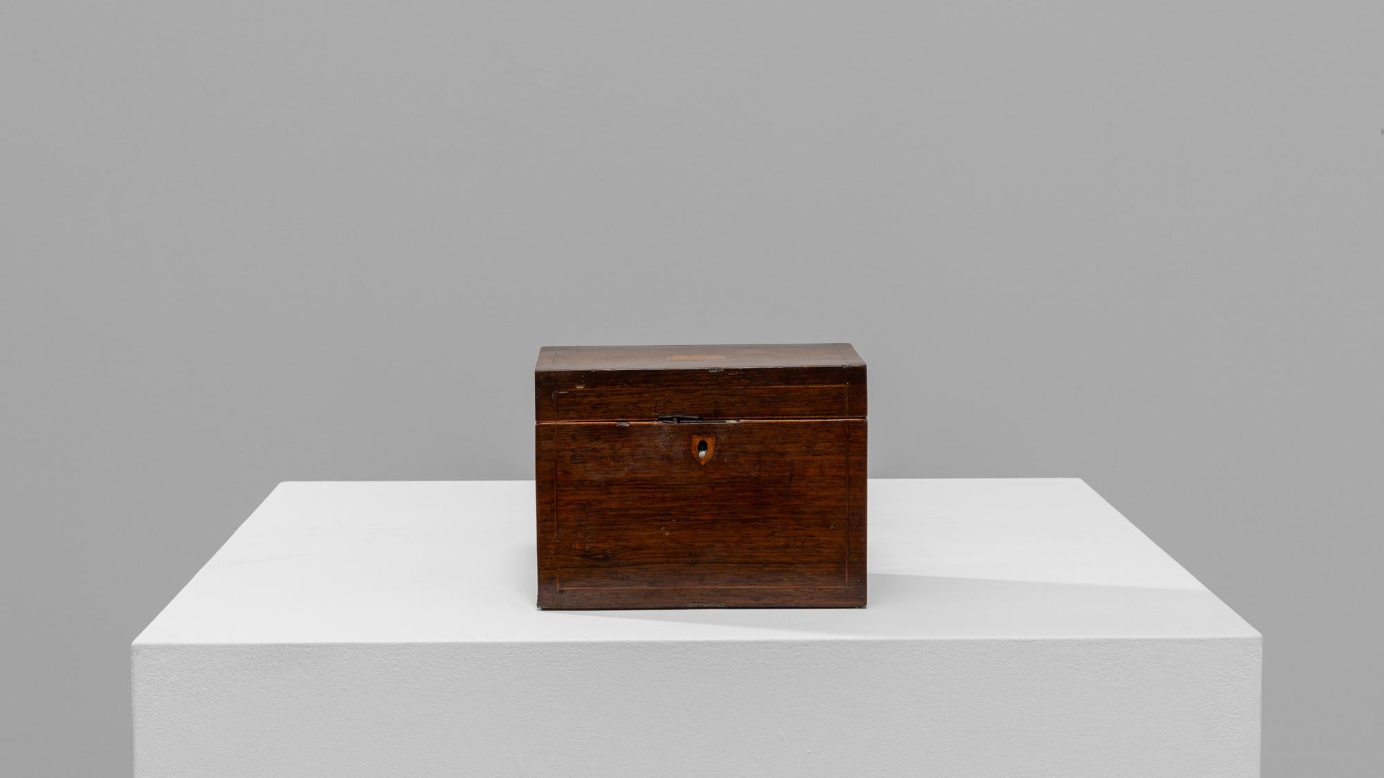 Step back in time with this charming 19th-century French wooden box, an exquisite piece that marries functionality with rustic elegance. Crafted from rich, dark wood, this box exudes a warm, inviting patina that speaks to its storied past. The