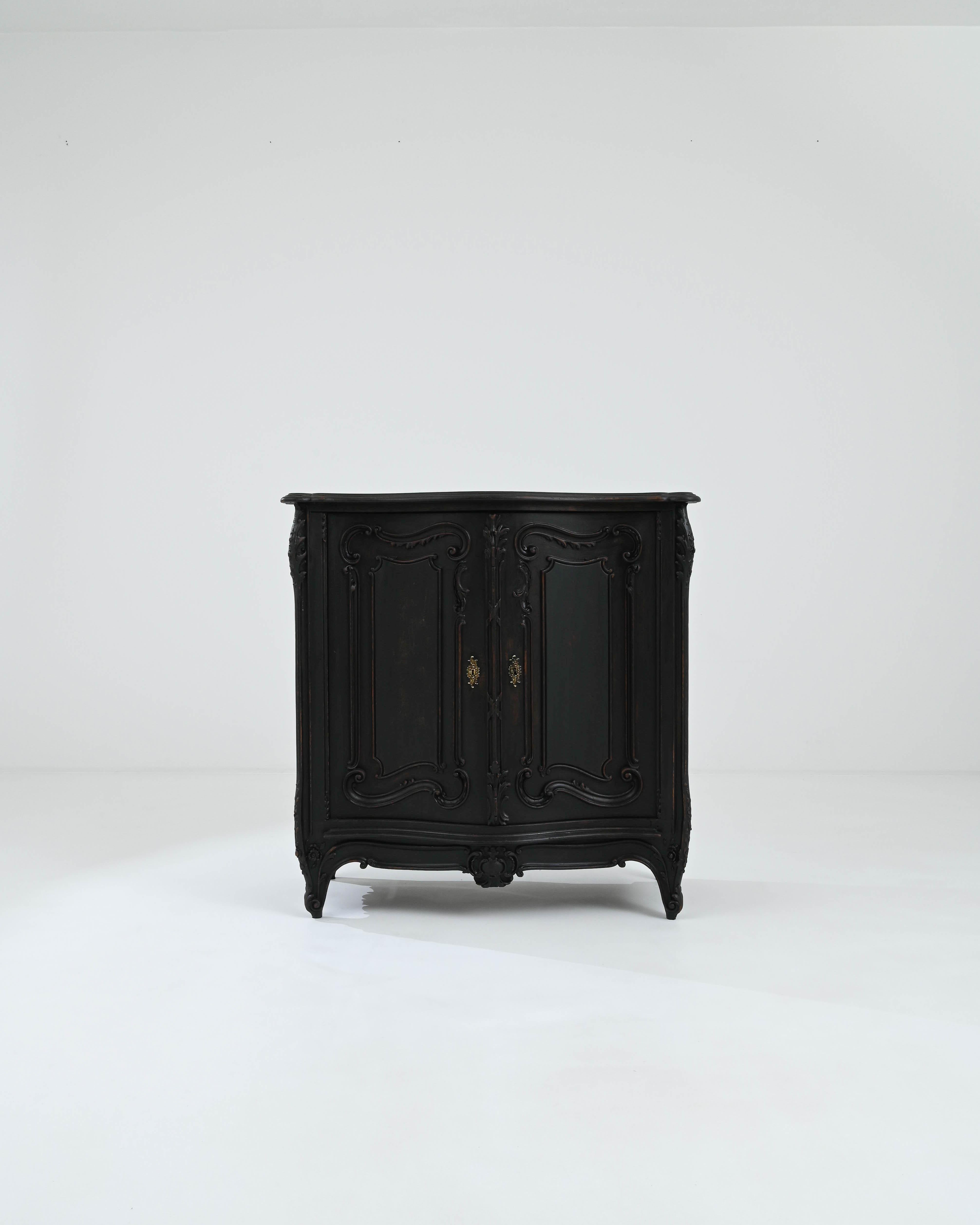 A wooden buffet created in 19th century France. Mysterious and undeniably beautiful, this classically sculpted buffet radiates a regality befitting a fairytale. Sumptuous scroll patterns line the paneled doors, aprons, and legs, animating its rich