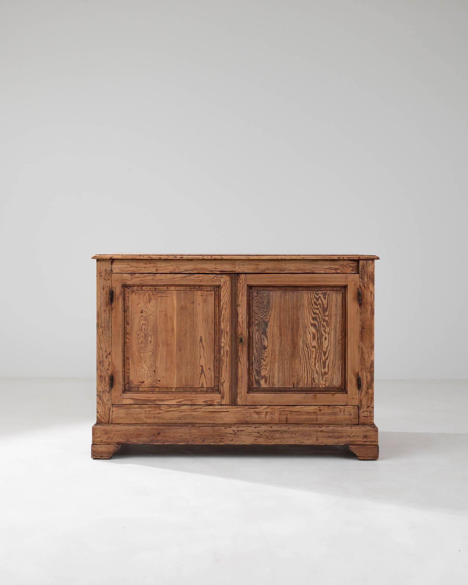 Indulge in the rustic charm of this authentic 19th Century French wooden buffet, a treasure trove of craftsmanship that echoes the storied past of provincial France. Each glance reveals the rich patina and wood grain that has deepened with time, a