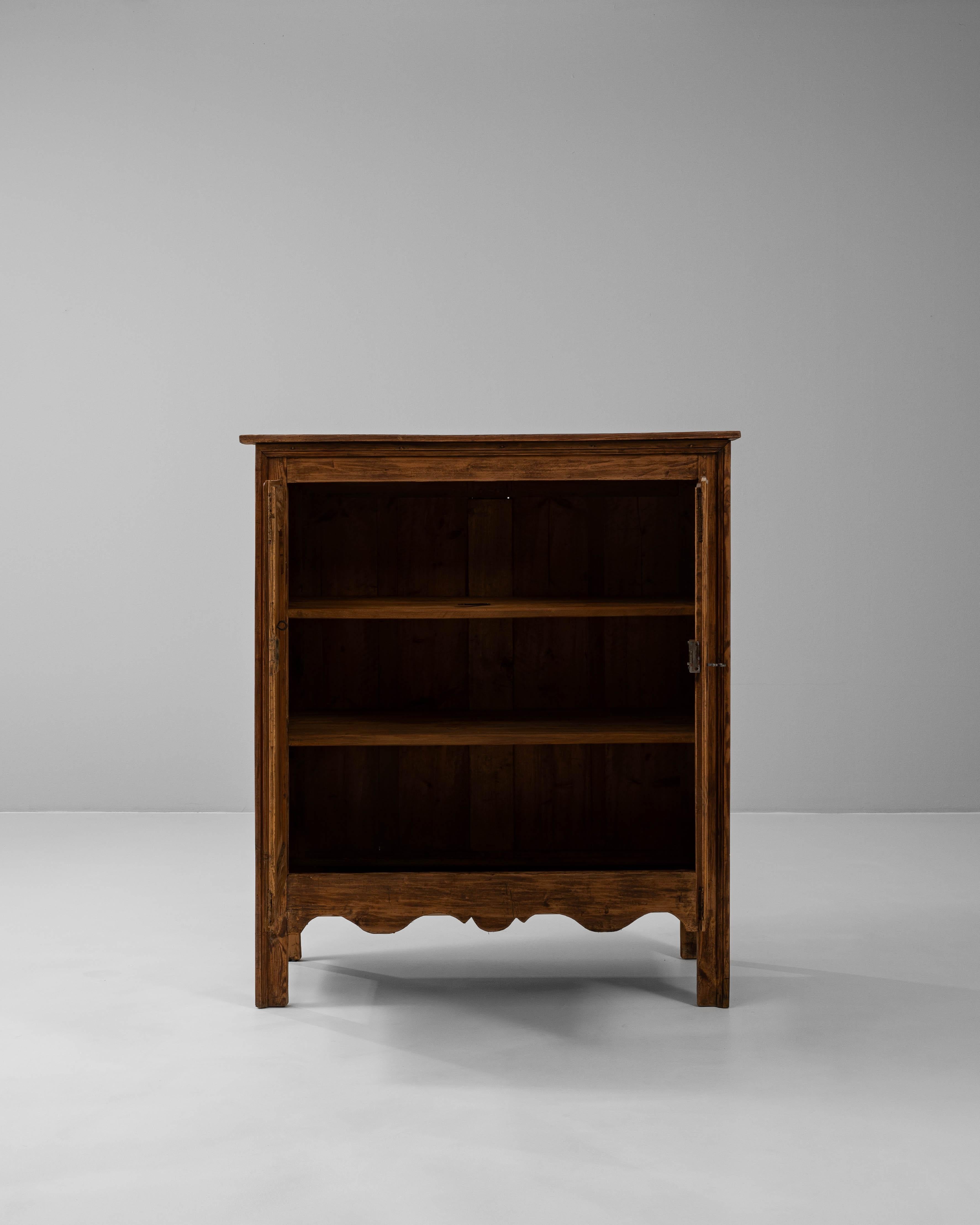 Questo buffet in legno francese del XIX secolo è uno splendido esempio di artigianato tradizionale e fascino rustico. Realizzato in legno massiccio con una patina ricca e calda, presenta eleganti porte doppie ornate da intricati pannelli intagliati