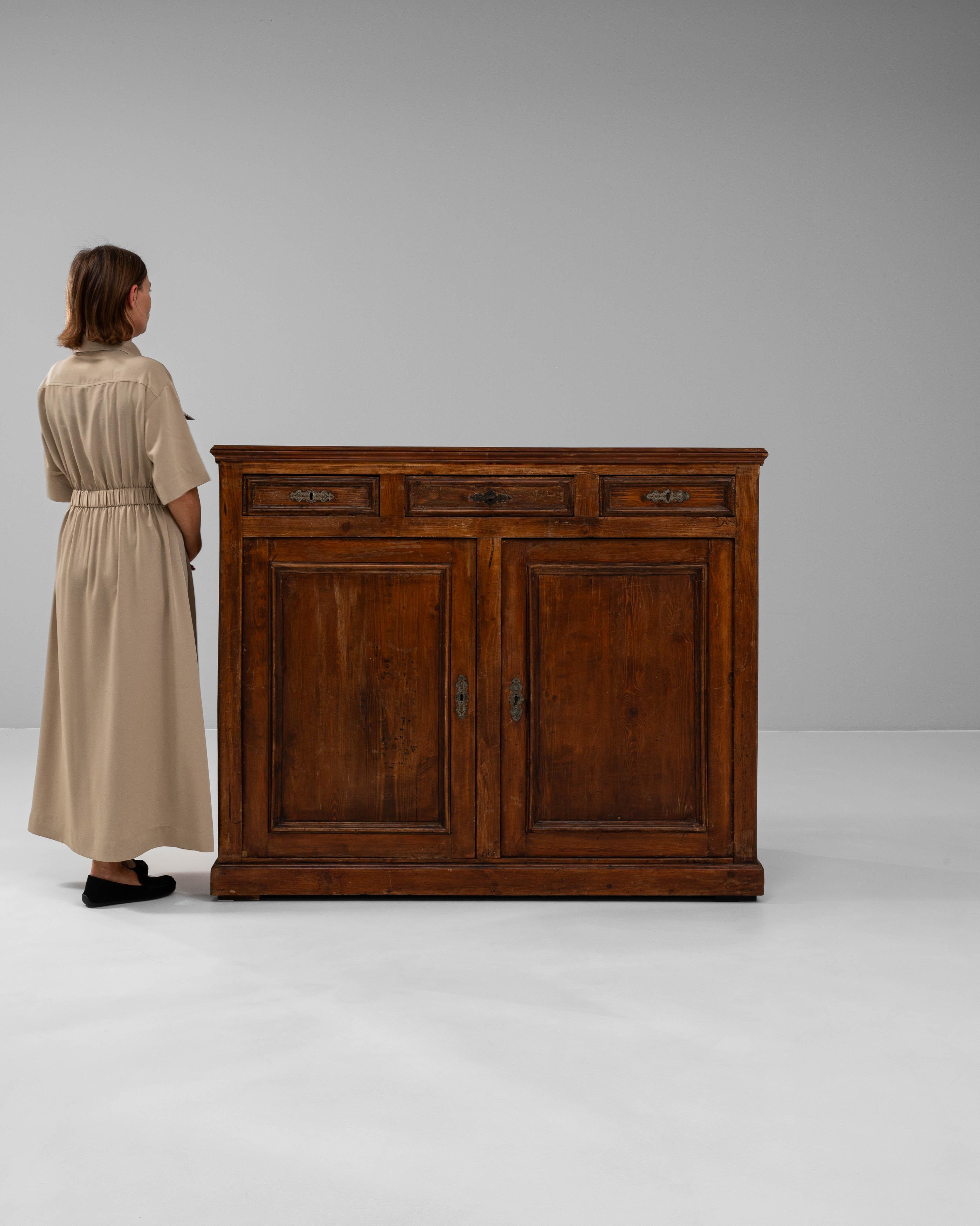 Questo buffet in legno francese del XIX secolo è un bell'esempio di artigianato tradizionale, che offre sia spazio che eleganza. Realizzato in legno dai toni ricchi e con una patina calda, il mobile ha una forma rettangolare con linee pulite e