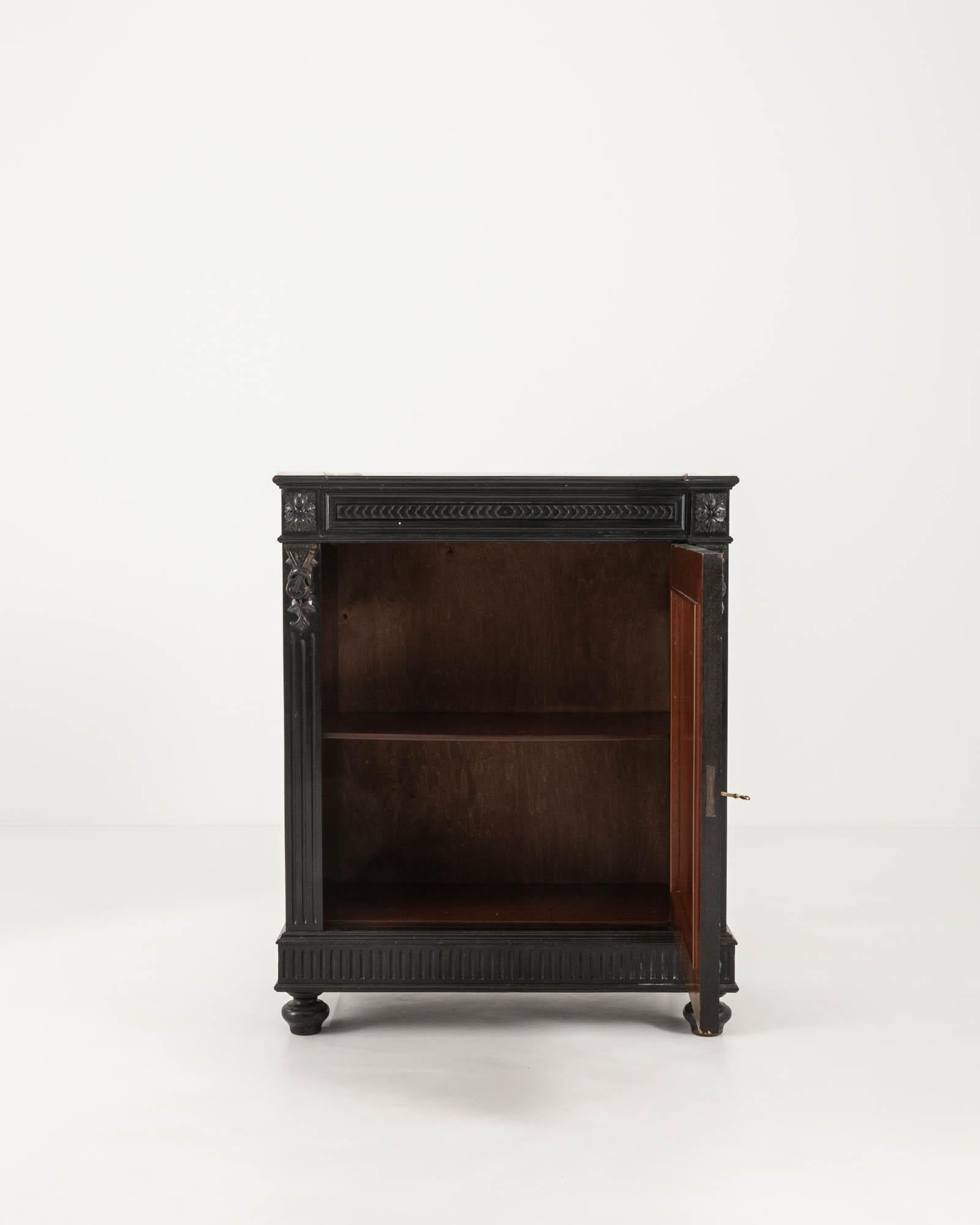 Discover the elegance and grandeur of the 19th century with this stunning French wooden buffet. Featuring a sleek, jet-black finish, this piece is topped with a sumptuous marble slab that adds an air of luxury and durability. The buffet is adorned