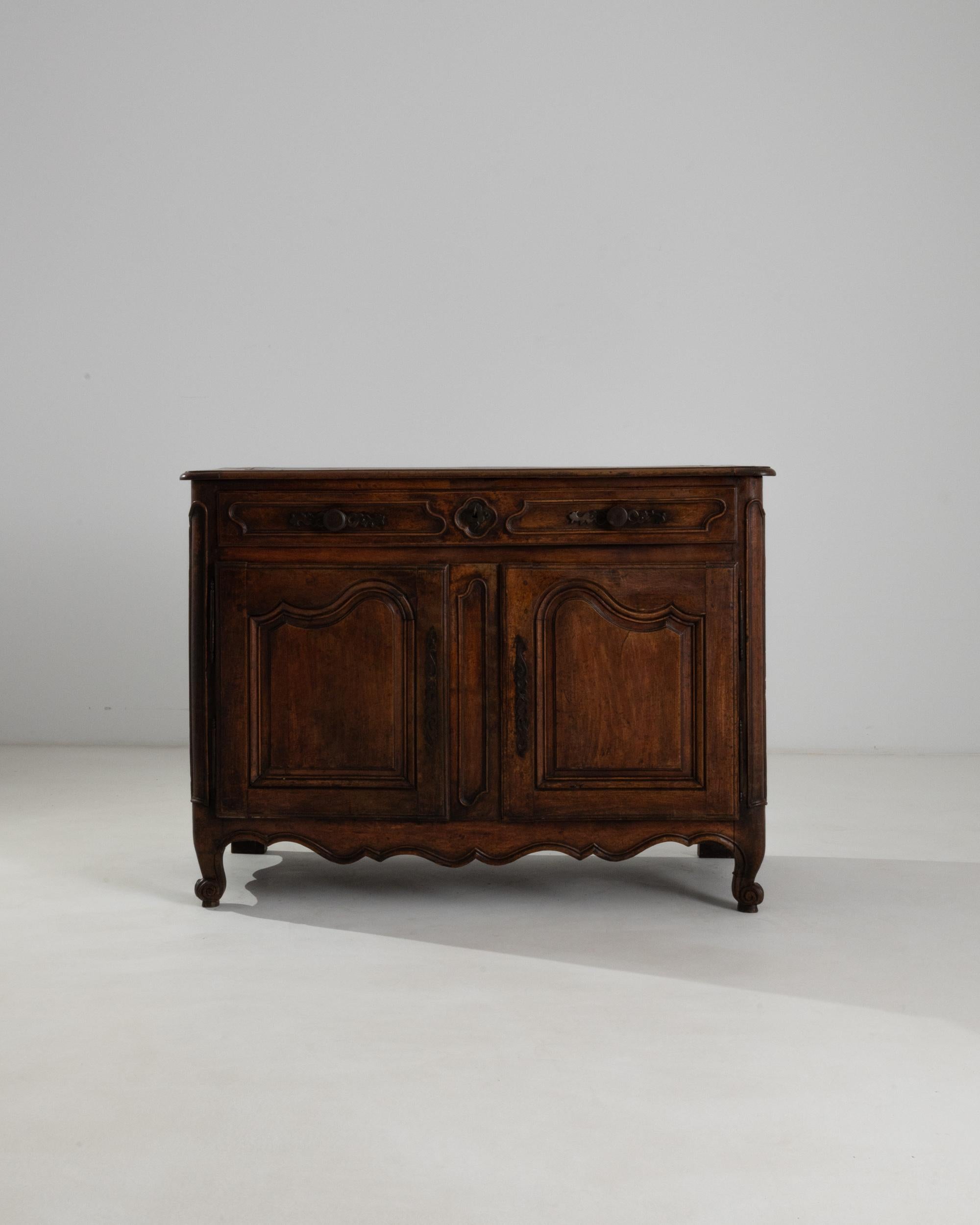 The patina of this antique buffet glows with a warmth and richness that can only be attained from the passing of time. Made in 19th century France, the polished surface of the wood has aged to a dark caramel hue with notes of deep garnet and cherry