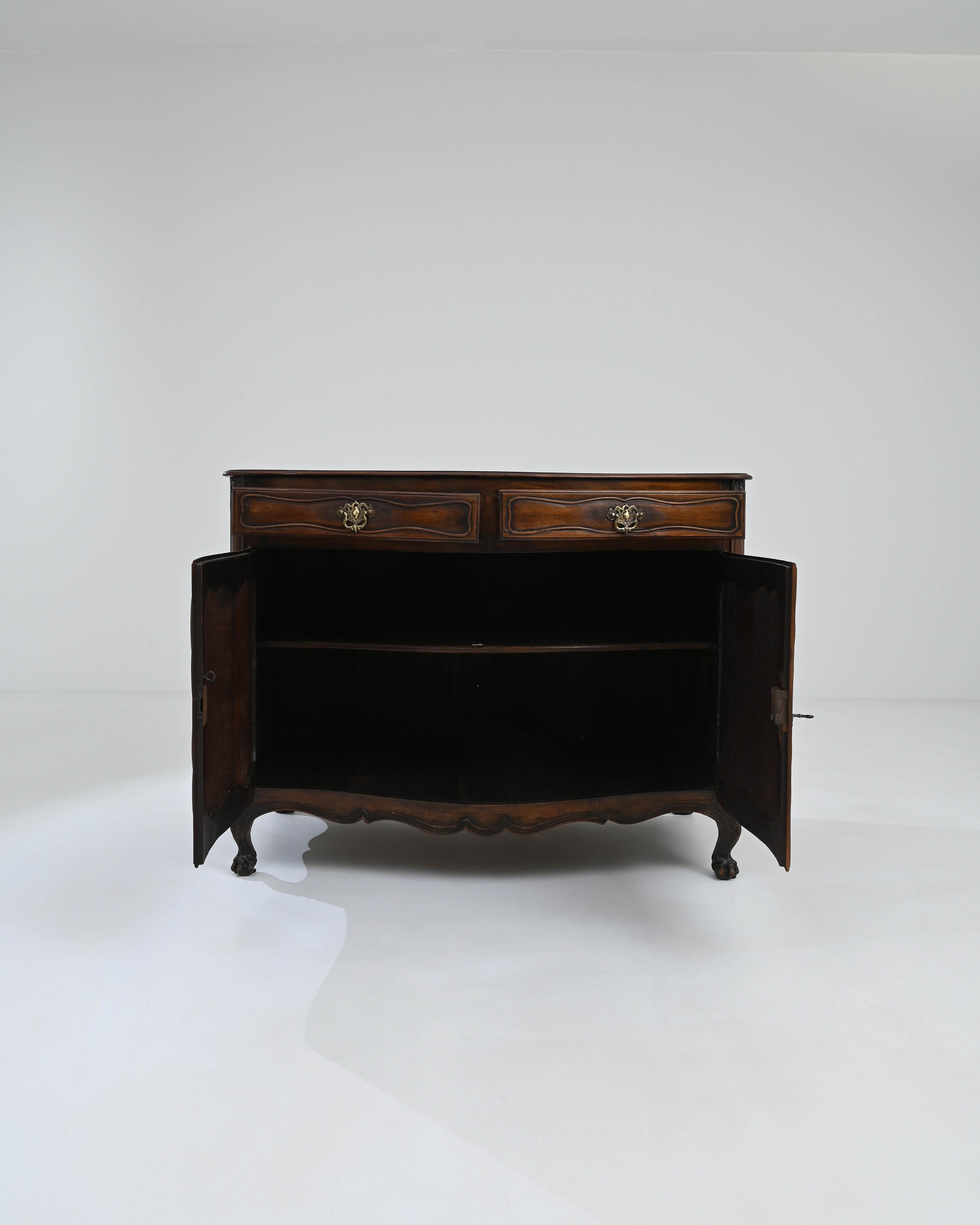 Immerse yourself in the timeless charm of this 19th Century French Wooden Buffet, showcasing its original patina for a touch of authenticity. This exquisite buffet, with its captivating carvings and gracefully curved cabriole legs, speaks to the