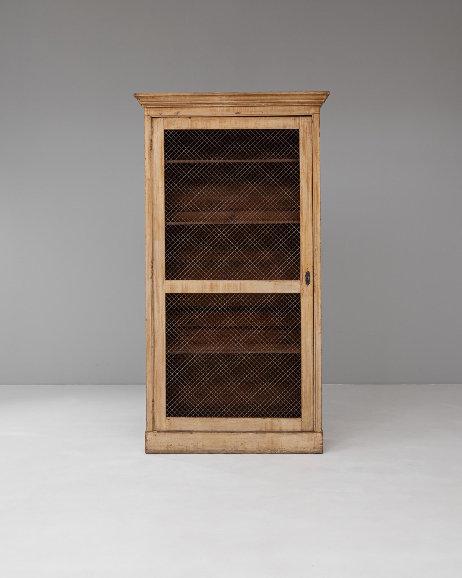 Questo mobile francese del XIX secolo in legno con rete metallica è un bellissimo esempio di design provinciale rustico combinato con una pratica funzionalità. Realizzato in legno massiccio, il mobile ha una forma rettangolare alta con un'unica anta