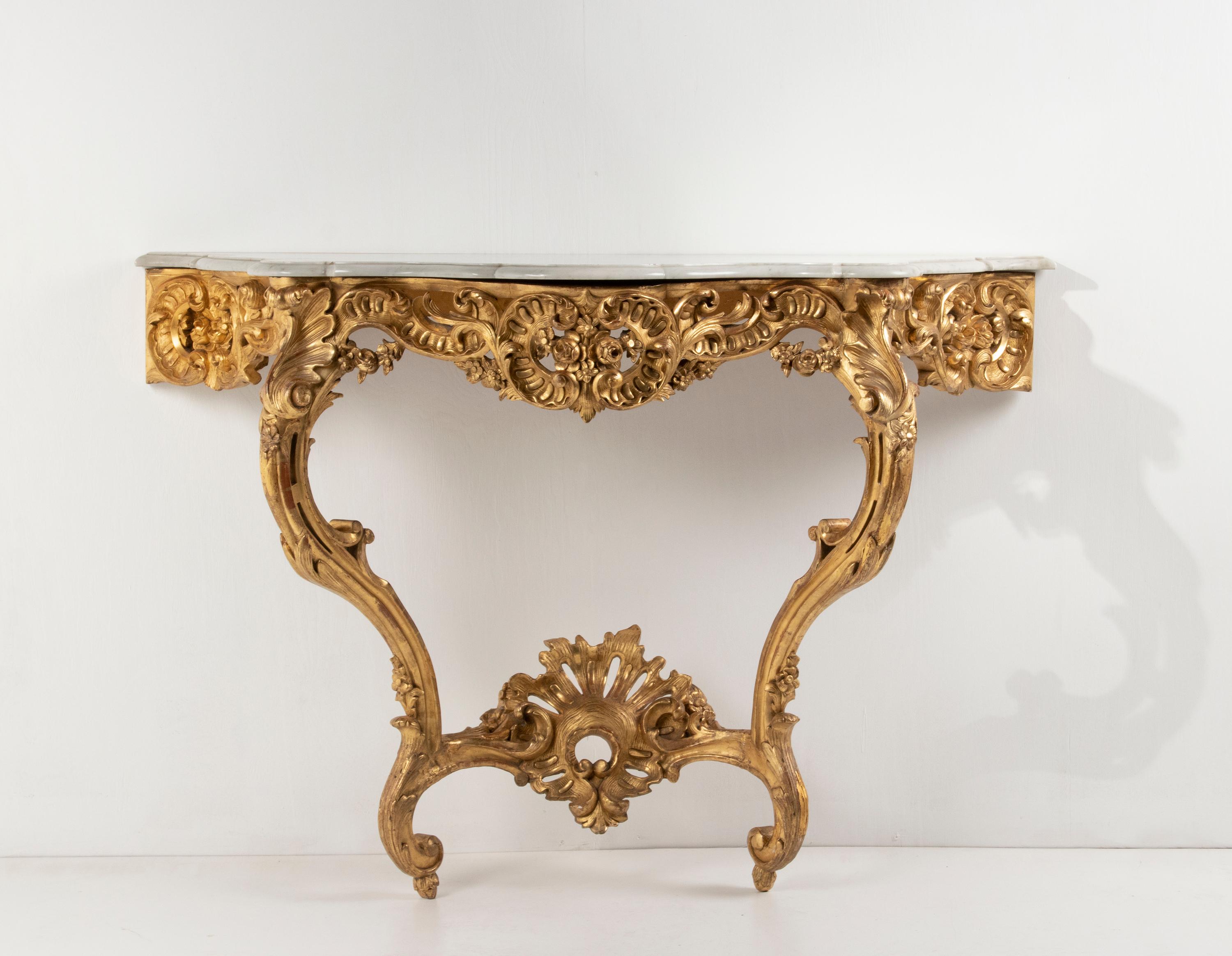 Beautiful antique French Napoleon III console table.
The table has beautiful carvings and is gilded with gold leaf.
The marble top has a profiled edge and curved shapes. This is Carrara marble, a very white type of marble.
The wooden base has an