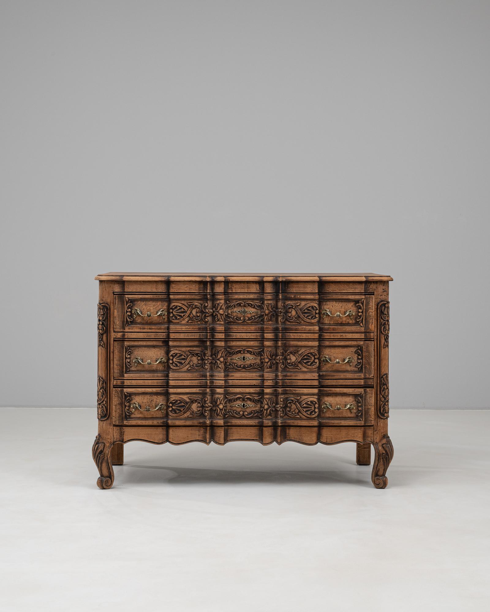 This 19th century French wooden chest of drawers exemplifies the opulence of the Rococo Revival style, showcasing intricate hand-carved motifs and a sinuous serpentine front. Crafted from richly toned wood with a deep patina, the chest features