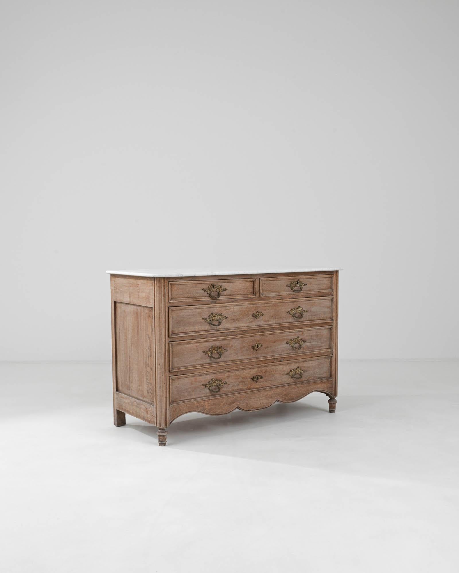Enhance your home with the elegant sophistication of this 19th Century French Wooden Chest of Drawers, crowned with a luxurious marble top. This exquisite piece features a graceful serpentine front and is adorned with intricate, ornate metal pulls