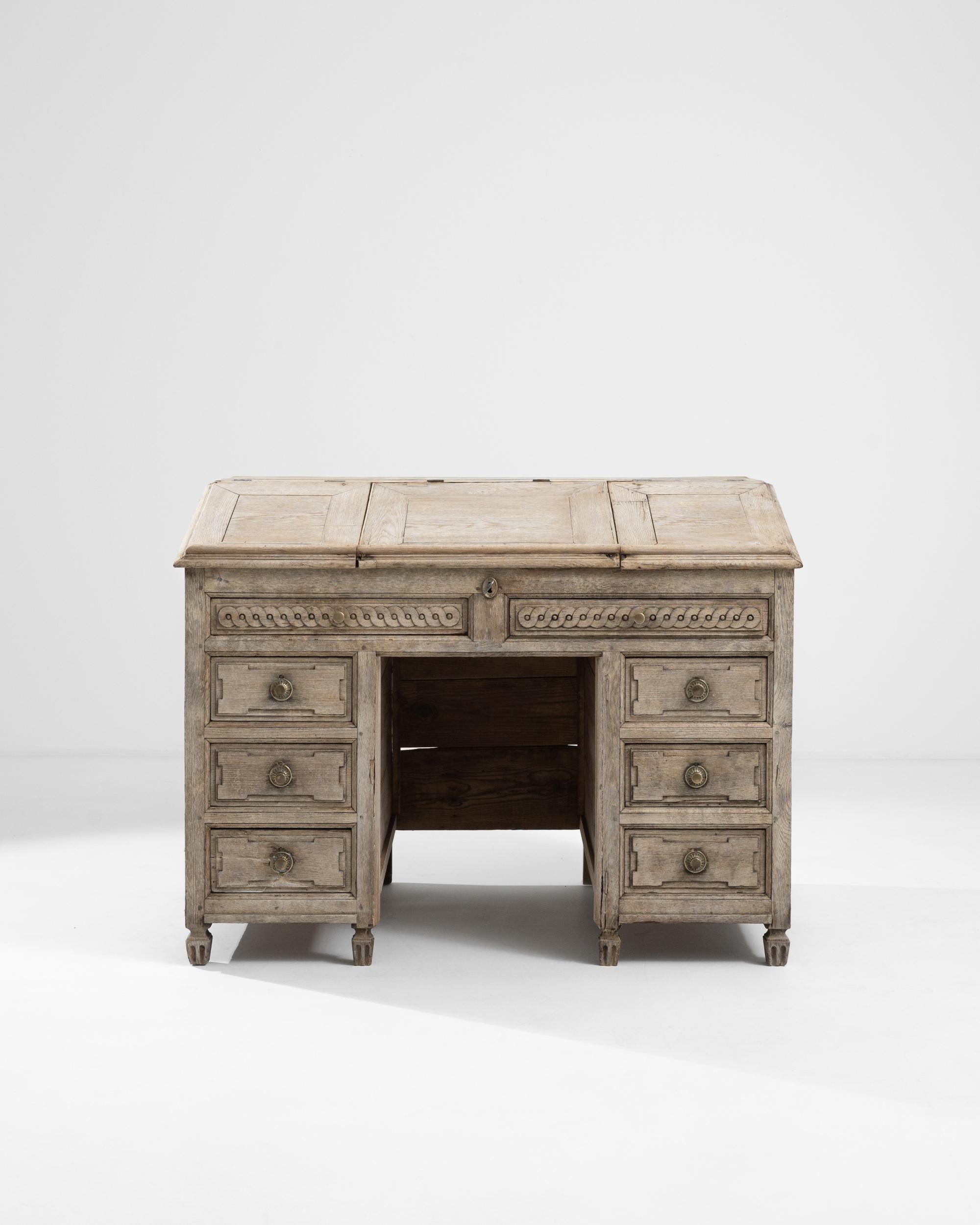 A wooden desk from 19th century France. The lower portion of this exquisitely crafted desk is composed of four symmetrical sliding drawers, in addition to a removable top that reveals additional ample storage space and four more hidden drawers. The