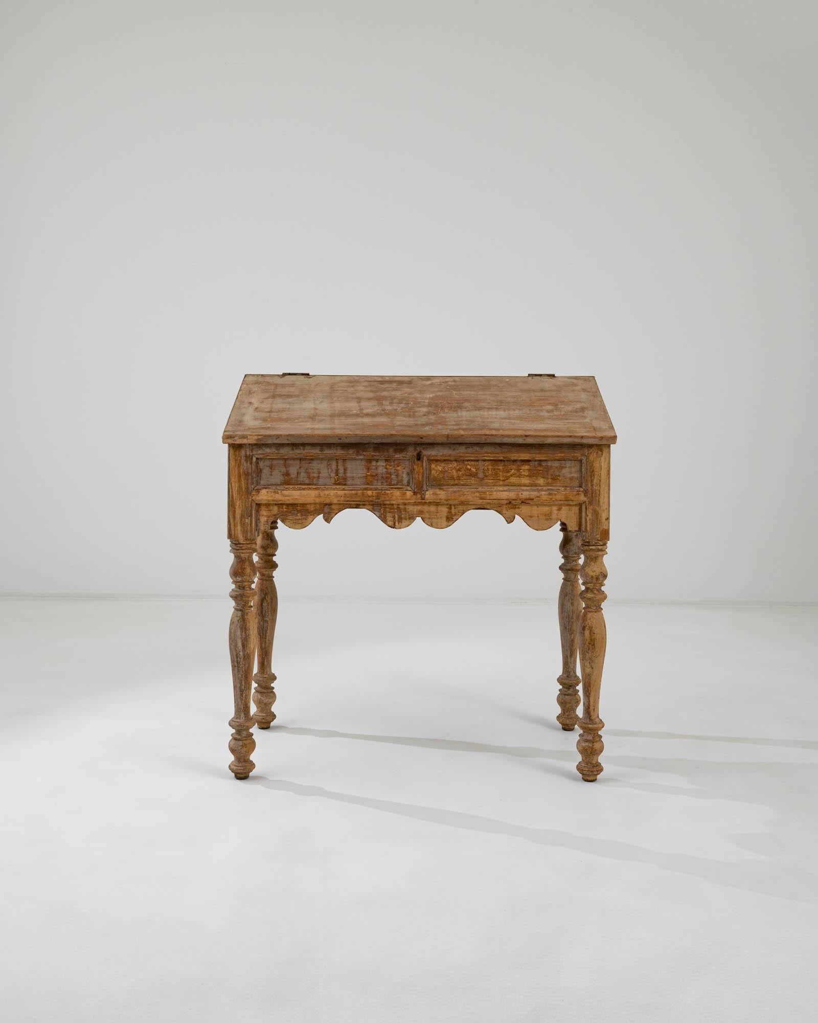 A wooden desk created in 19th century France. Dignified and glowing golden, this classical writing desk oozes a one of a kind beauty and sense of history. Sumptuously scalloped aprons and lathed legs engender a feeling of loving craft and a level of