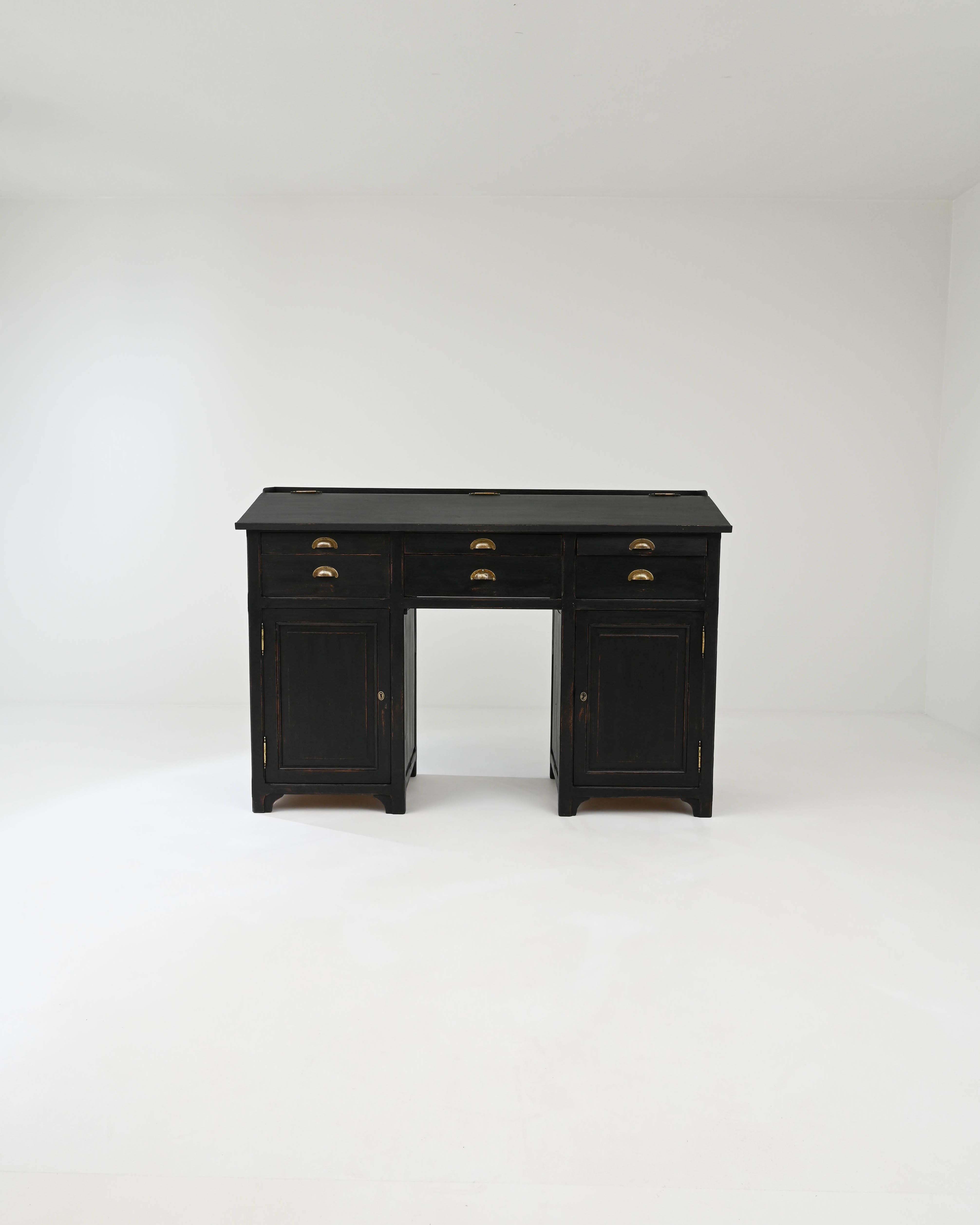 The commanding presence of this 19th-century French desk is attributed to its square pedestal structure. The ensemble of six drawers is perched upon two sturdy legs, which also double as spacious compartments. The tabletop can be raised, offering