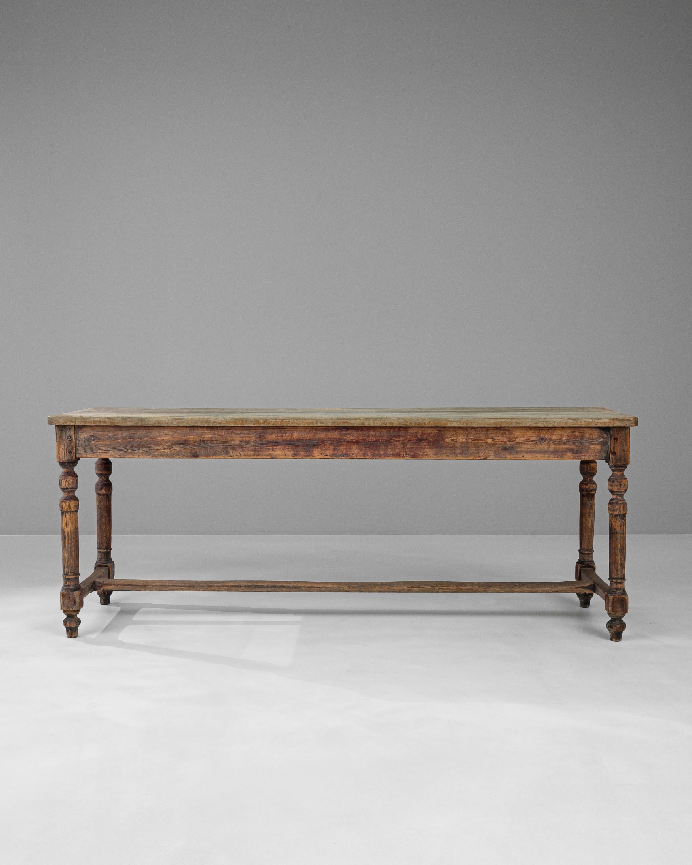 Revel in the grandeur of the 19th Century with this French Wooden Dining Table, a true masterpiece that echoes the splendor of bygone eras. Each glance at this table reveals the depth of its heritage, showcased in the exquisitely turned legs and the