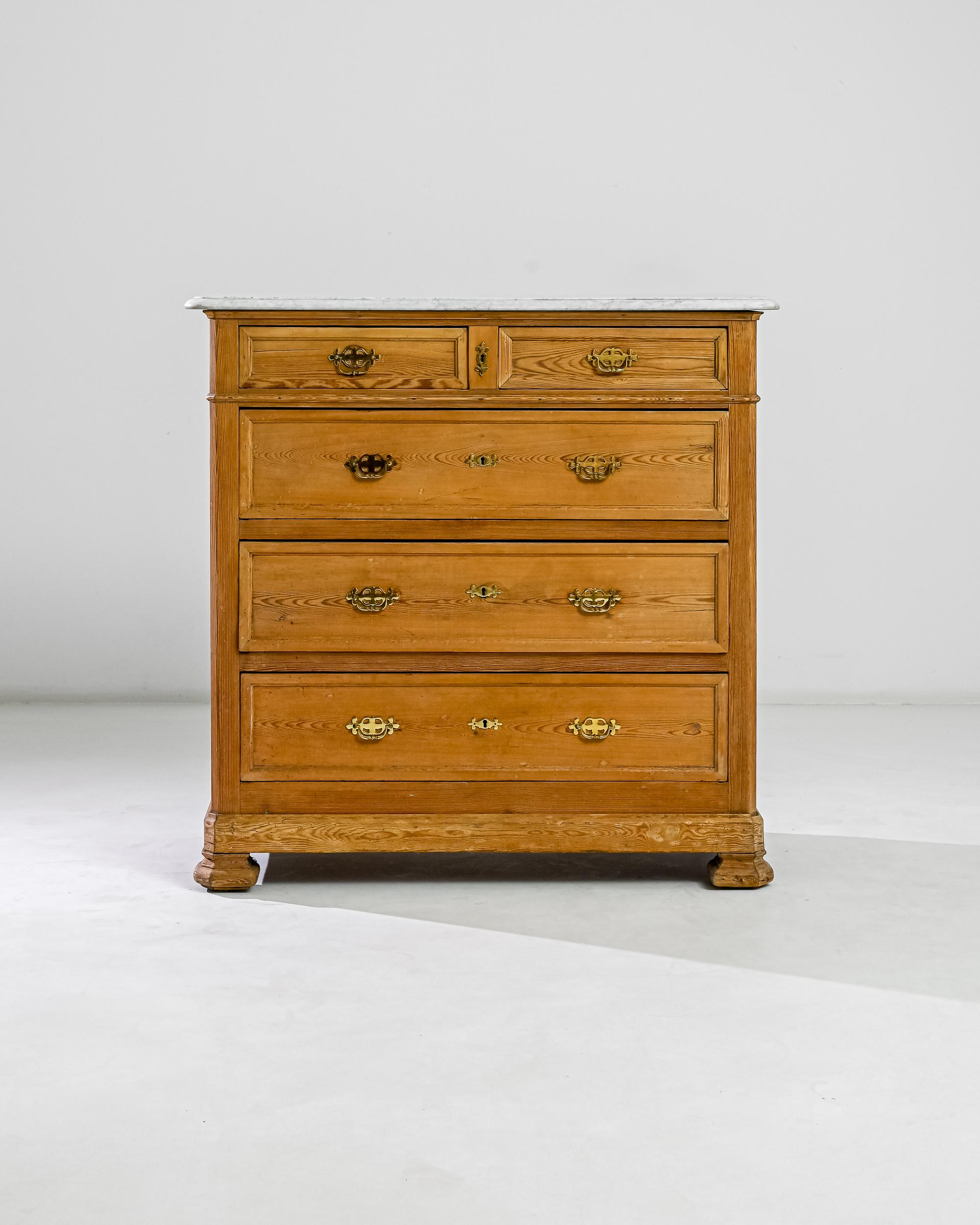 This 19th century chifonier made in France boasts a refined marble top, resting over a wooden case with three deep and two shallow drawers adorned by gilded bail pulls. A curious angularity of its sturdy feet accentuate a noble neoclassical profile