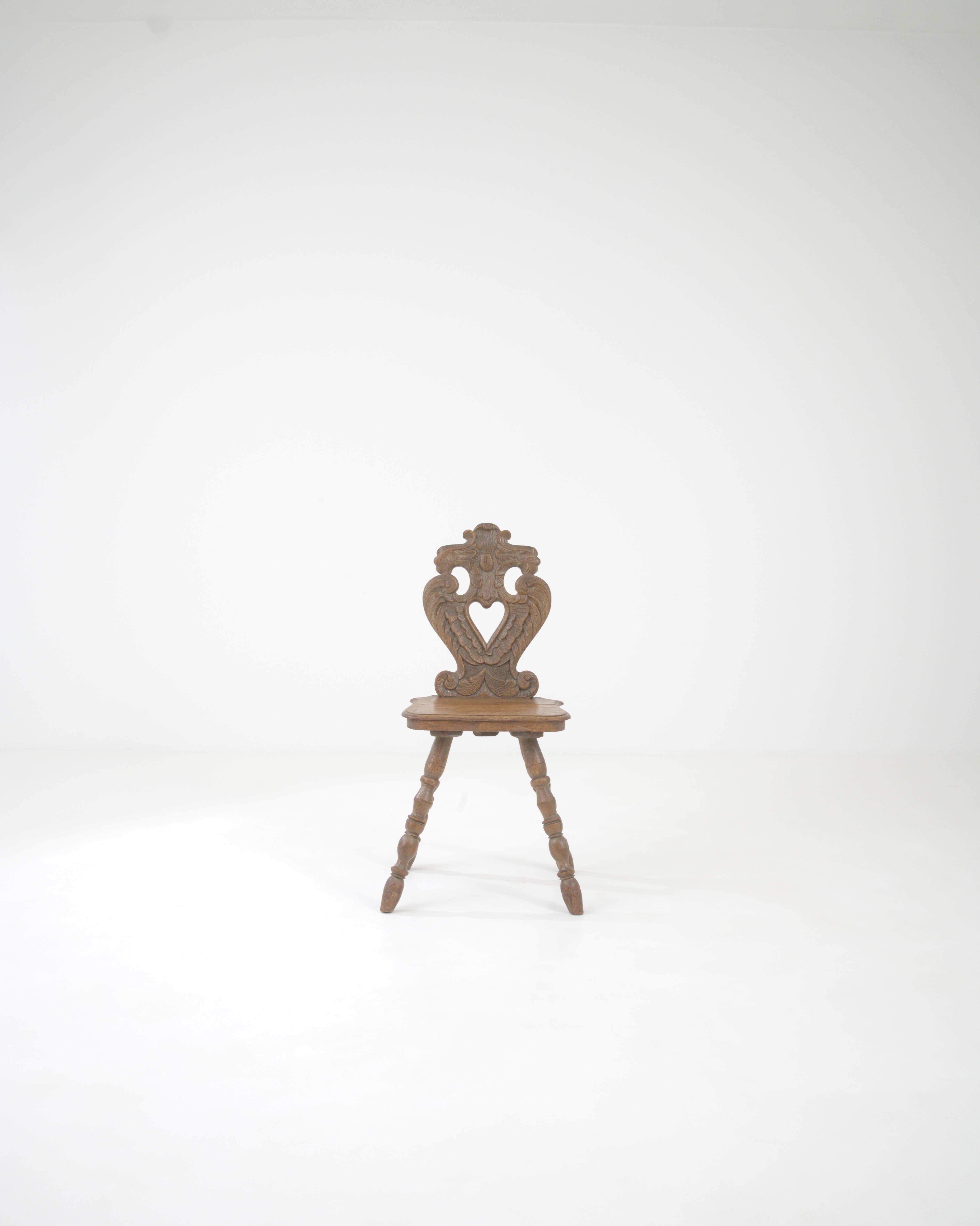 Step back in time with this exquisitely crafted 19th Century French Wooden Chair, a statement piece that embodies the elegance of historical French design. The chair's heart-shaped backrest, adorned with intricate carvings, showcases the meticulous