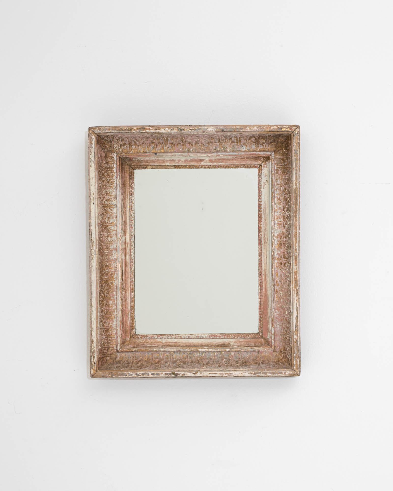 A wooden mirror created in 19th century France. With rustic yet elegant patterned wood and an attractively shaped frame, this mid-sized mirror offers a refined composition for reflection. The time-touched wood, mesmerizingly hand-carved with