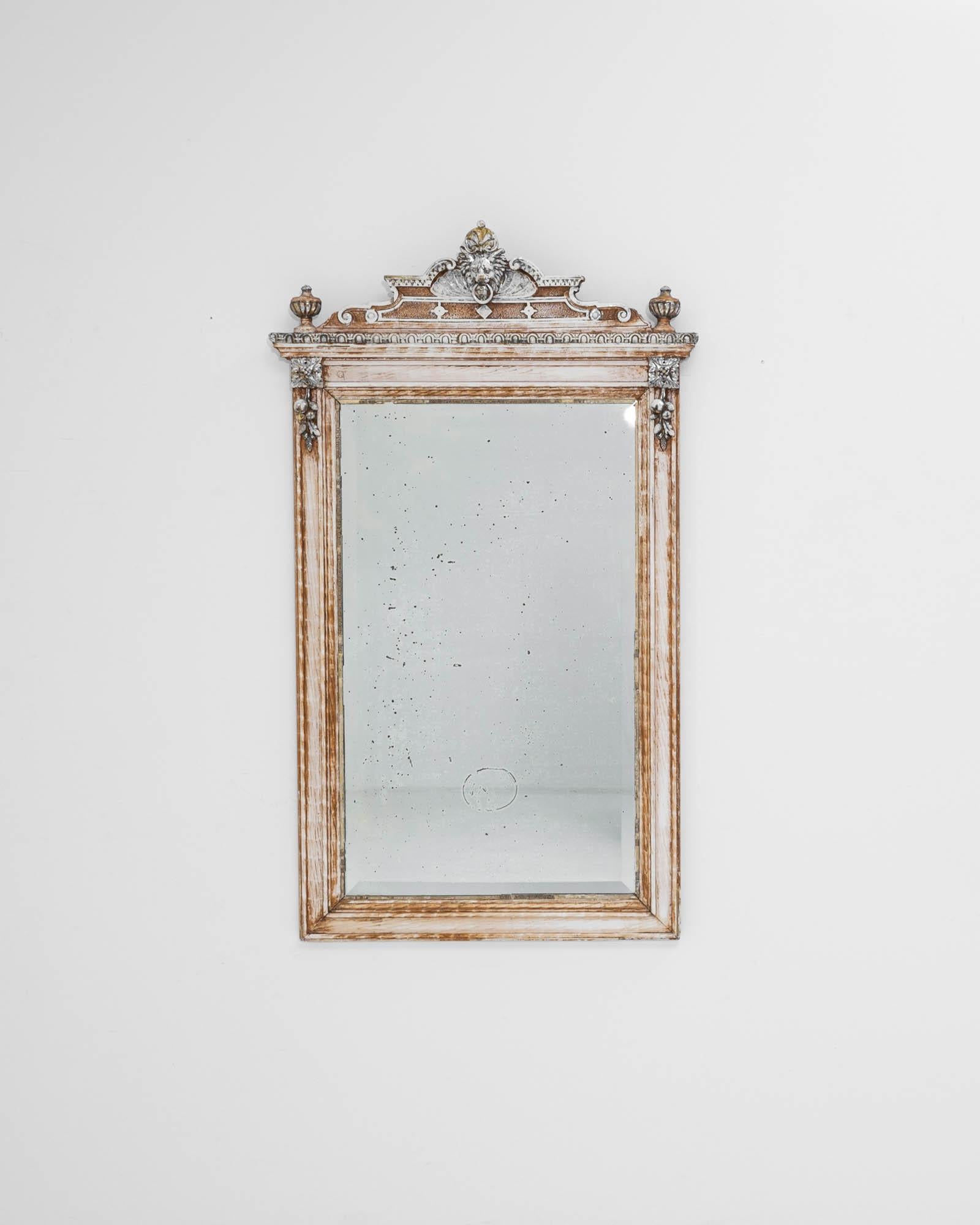 A wooden mirror created in 19th century France. This antique mirror radiates regality and a curious old-world sense of design and craftsmanship that leads one’s eye around its frame. Floral motifs, dazzling sculpted patterns, and a curious beast