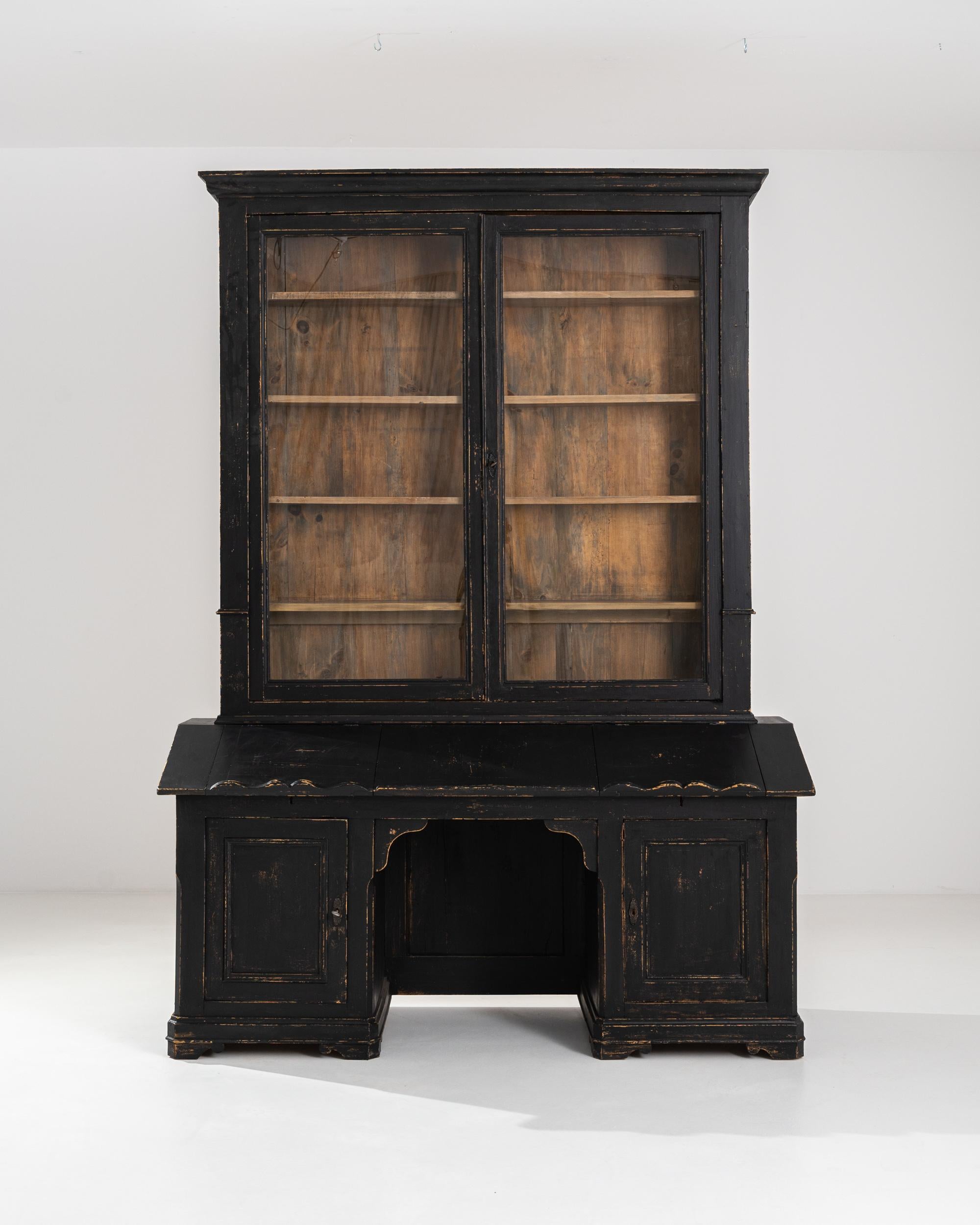 A vintage wooden vitrine from 19th century France. A gentle giant, this glass display case stands tall, emitting a powerful yet inviting ambience. Five large upper shelves offer a wealth of storage for inspiring curiosities, while two symmetrical