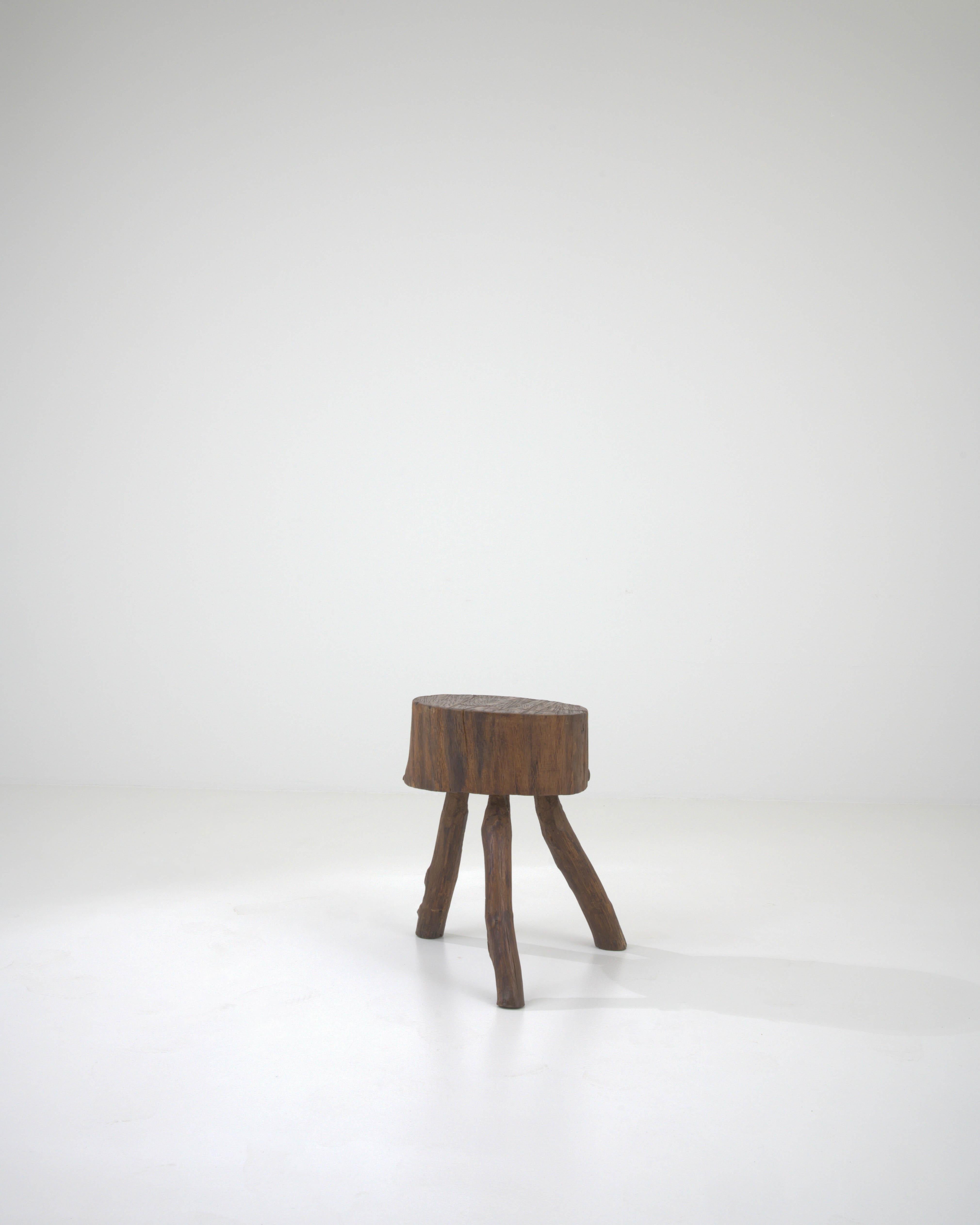 Step into the charm of the 19th century with this French Wooden Side Table, exuding a natural and primitive allure. The table boasts a distinctive round seat, offering a rustic and raw aesthetic reminiscent of its organic origins. Supported by three