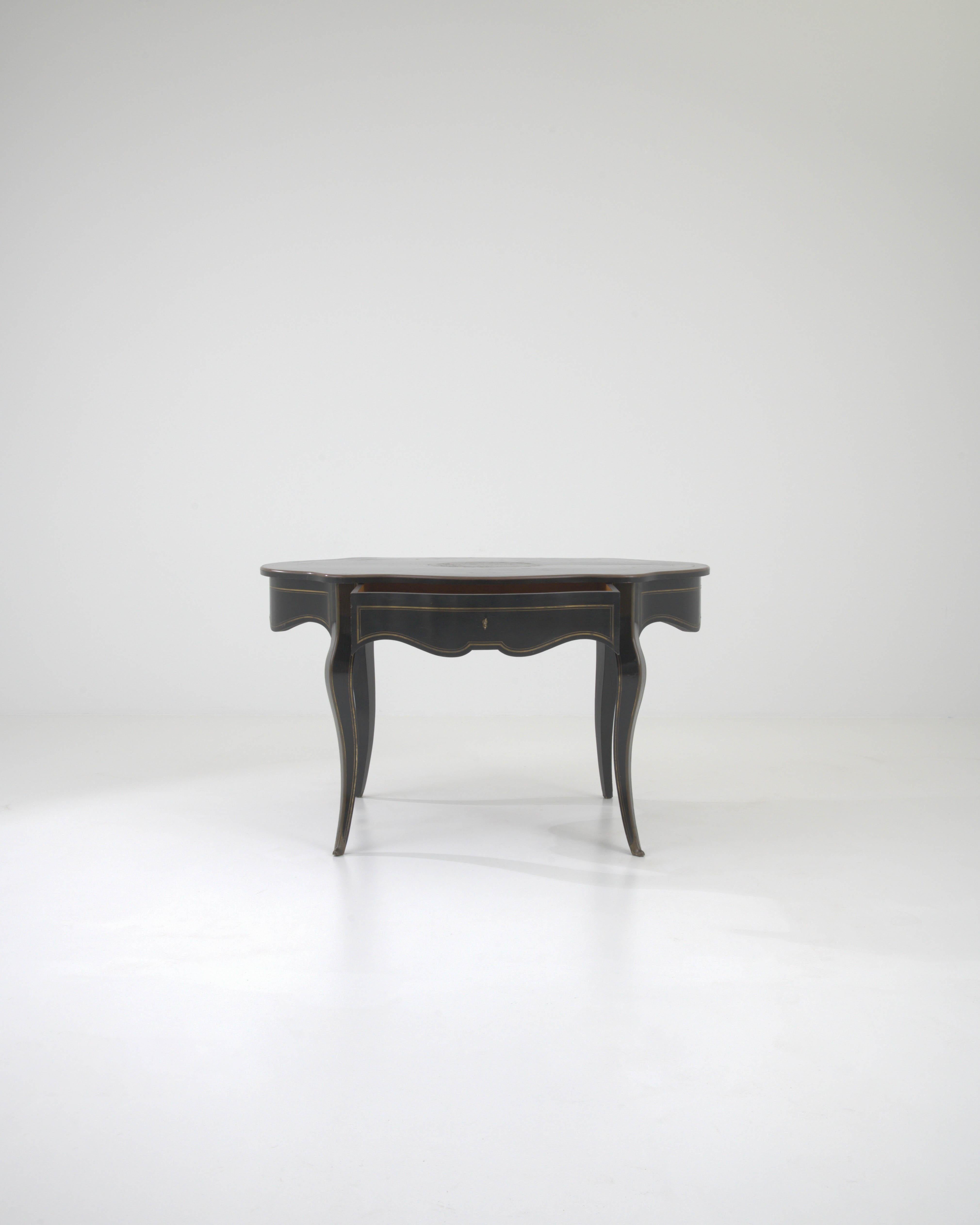 Step into the 19th century with this exquisite French Wooden Side Table featuring its original patina. The elegant black table boasts a scalloped apron that gracefully encircles the entire piece, creating a charming visual appeal. The oval top,