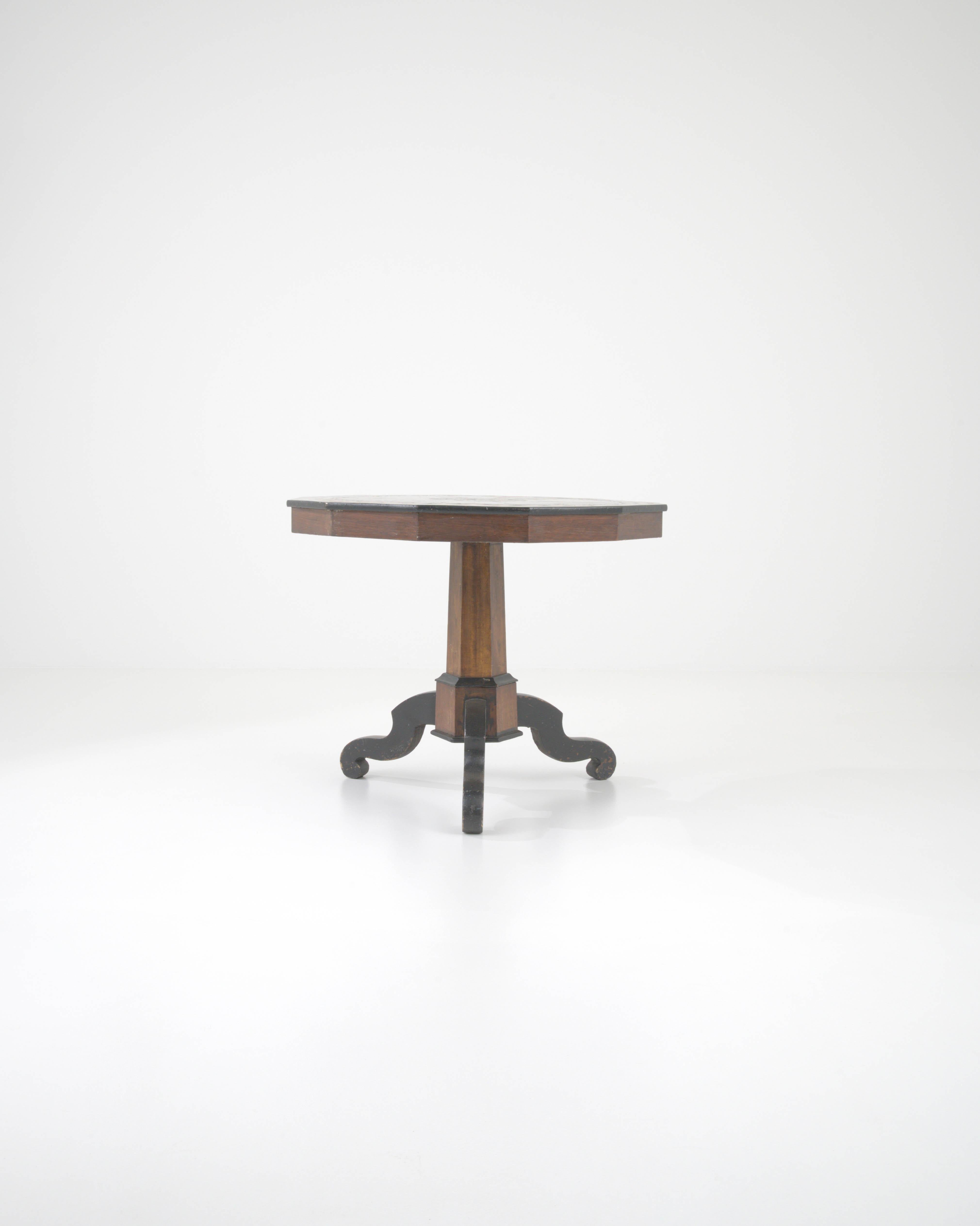 Transport yourself to the elegance of the 19th century with this French Wooden Side Table boasting its original rich walnut stain patina. The unique design features black legs that complement the dark patina, providing a striking contrast. The top