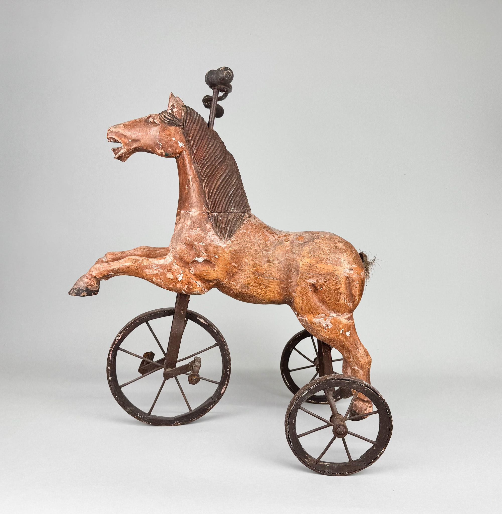 Antique horse tricycle made of wood and metal. Made in France in the late 19th century.