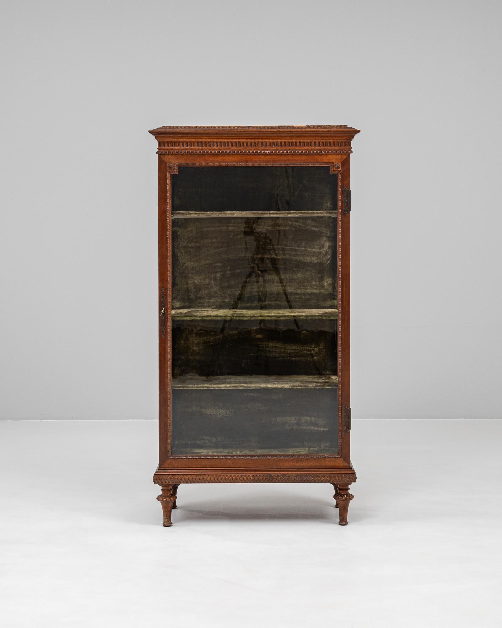This 19th century French wooden vitrine captures the refined elegance of classical French design with remarkable detail and craftsmanship. The solid wood frame features delicate hand-carved ornamentation, including floral rosettes and acanthus