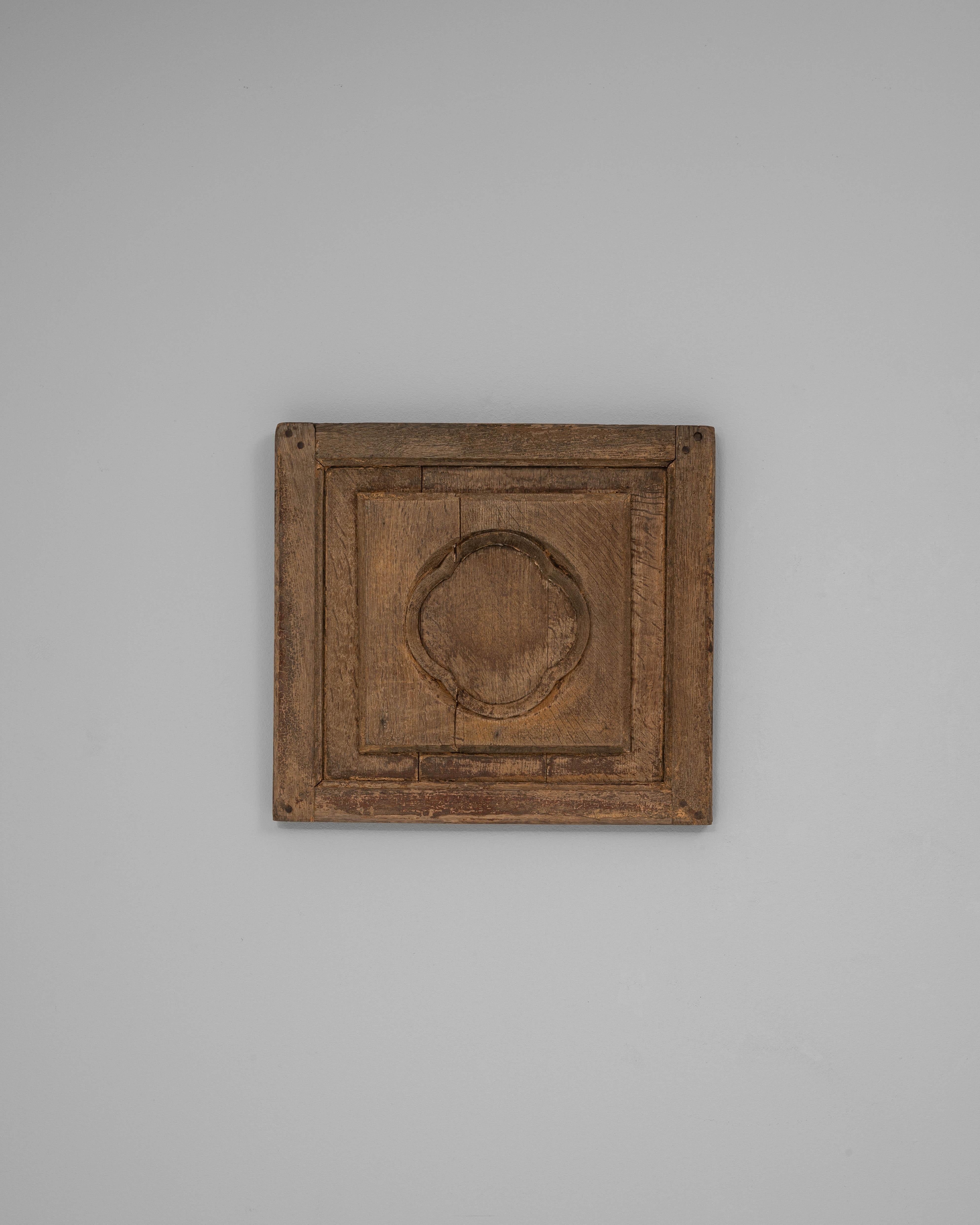Cette décoration murale française en bois du XIXe siècle présente une sculpture architecturale sobre, encadrée dans une simple bordure moulée, qui incarne l'élégance discrète de l'artisanat provincial. Le médaillon central - doucement arrondi et