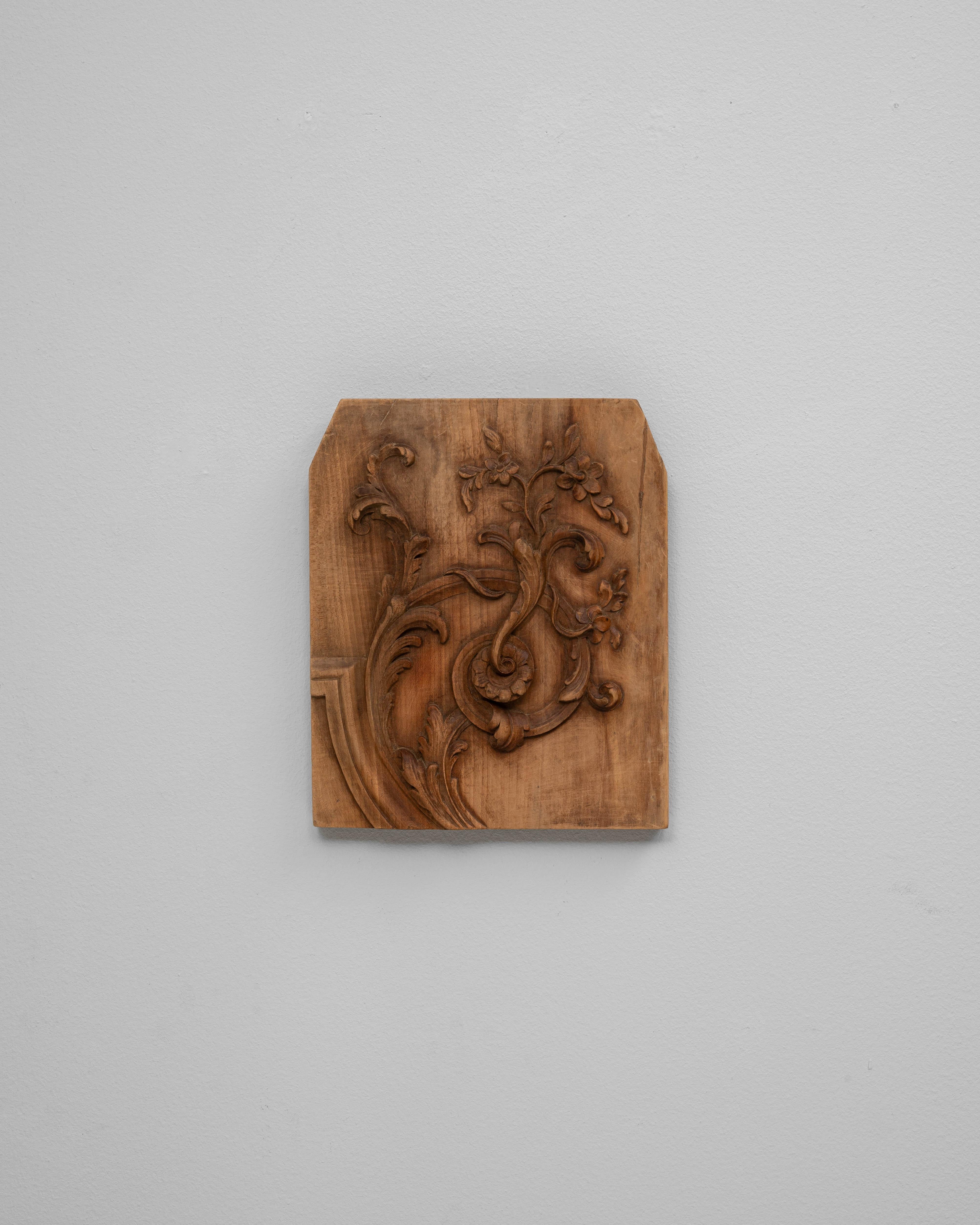 Cette décoration murale française en bois du XIXe siècle présente un motif magnifiquement sculpté d'inspiration rococo, défini par des volutes fluides, un feuillage délicat et des détails floraux doucement arrondis. L'ornementation asymétrique, avec