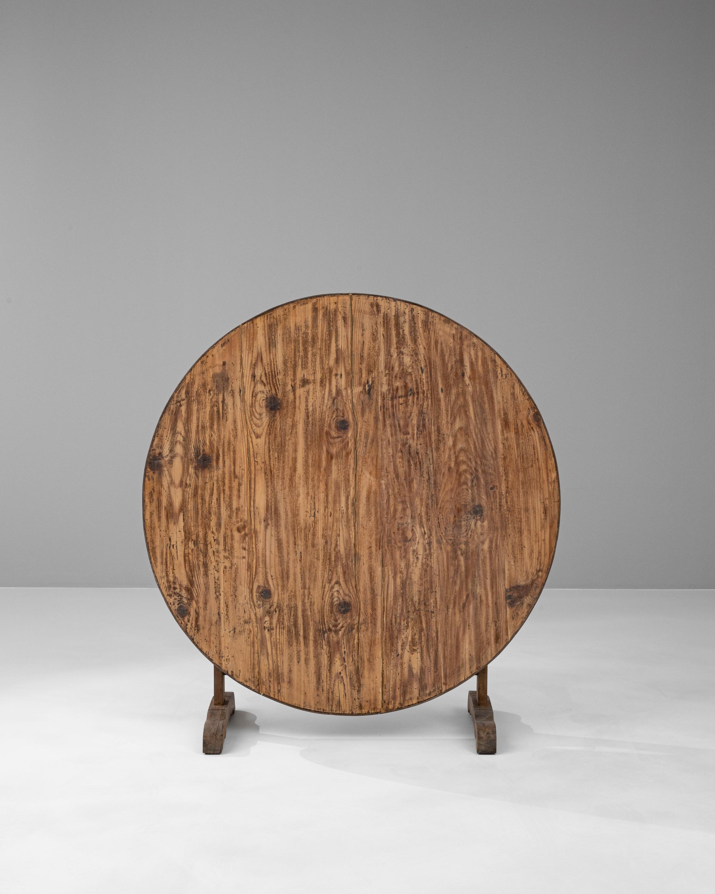 Embrace the art of oenophilia with our 19th Century French Wooden Wine Tasting Table, a piece steeped in tradition and designed for the connoisseur. This authentic table has witnessed countless wine tastings, with its circular top ideally shaped to