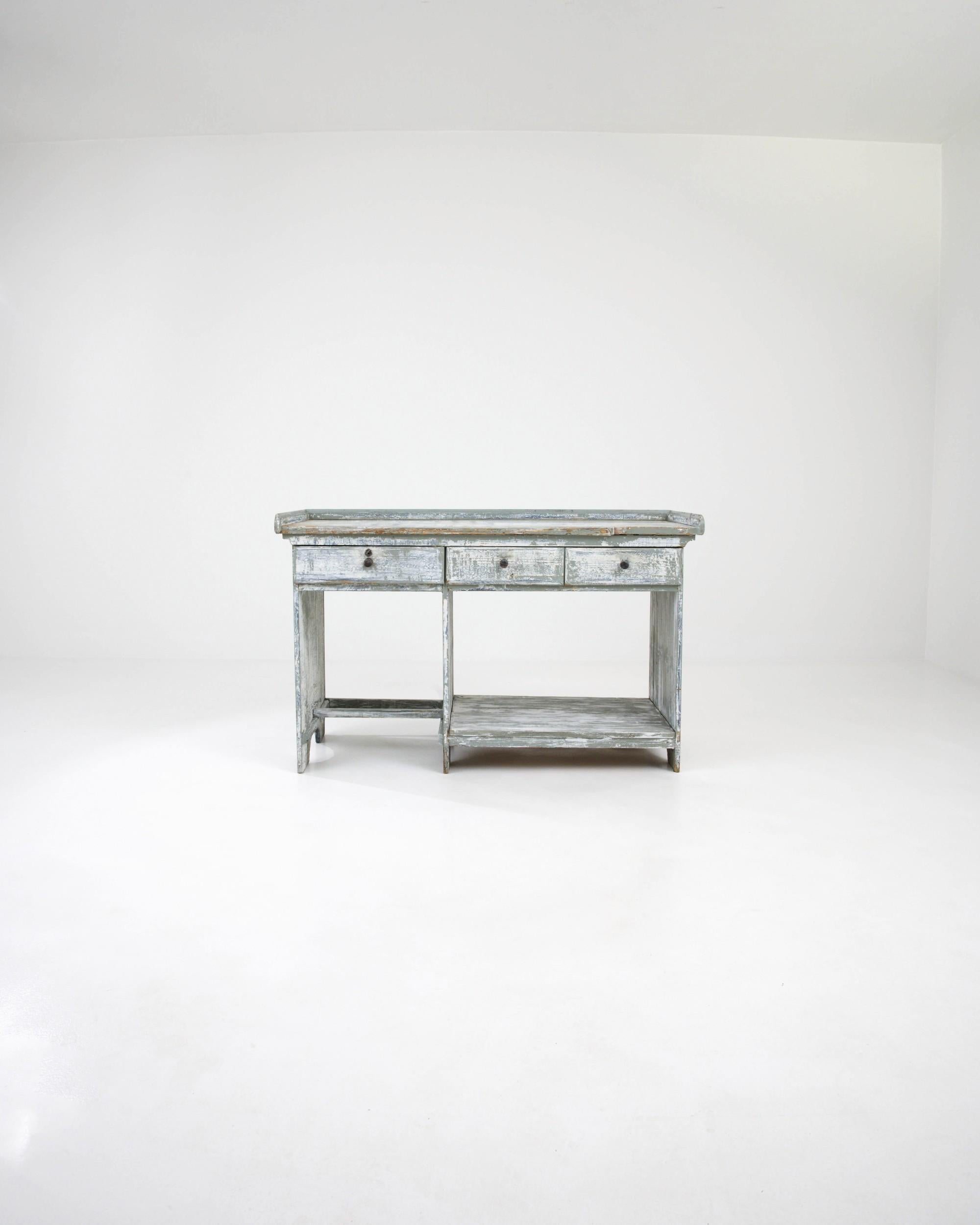 Made in France during the 19th century, this antique work table features an unusual structure with three drawers — two regular ones and one tip-out drawer — suspended above a lower shelf and kneehole desk, to keep specialized tools and materials