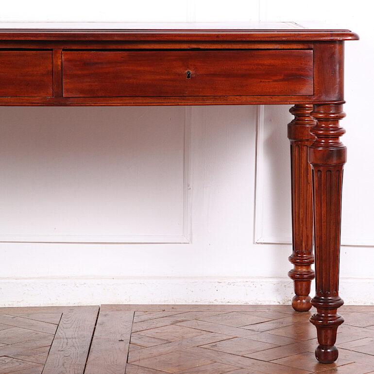 19th Century French writing table or desk in mahogany with two drawers in the skirt and a recently-fitted gilt tooled leather writing surface. Raised and turned and fluted tapering legs.

 