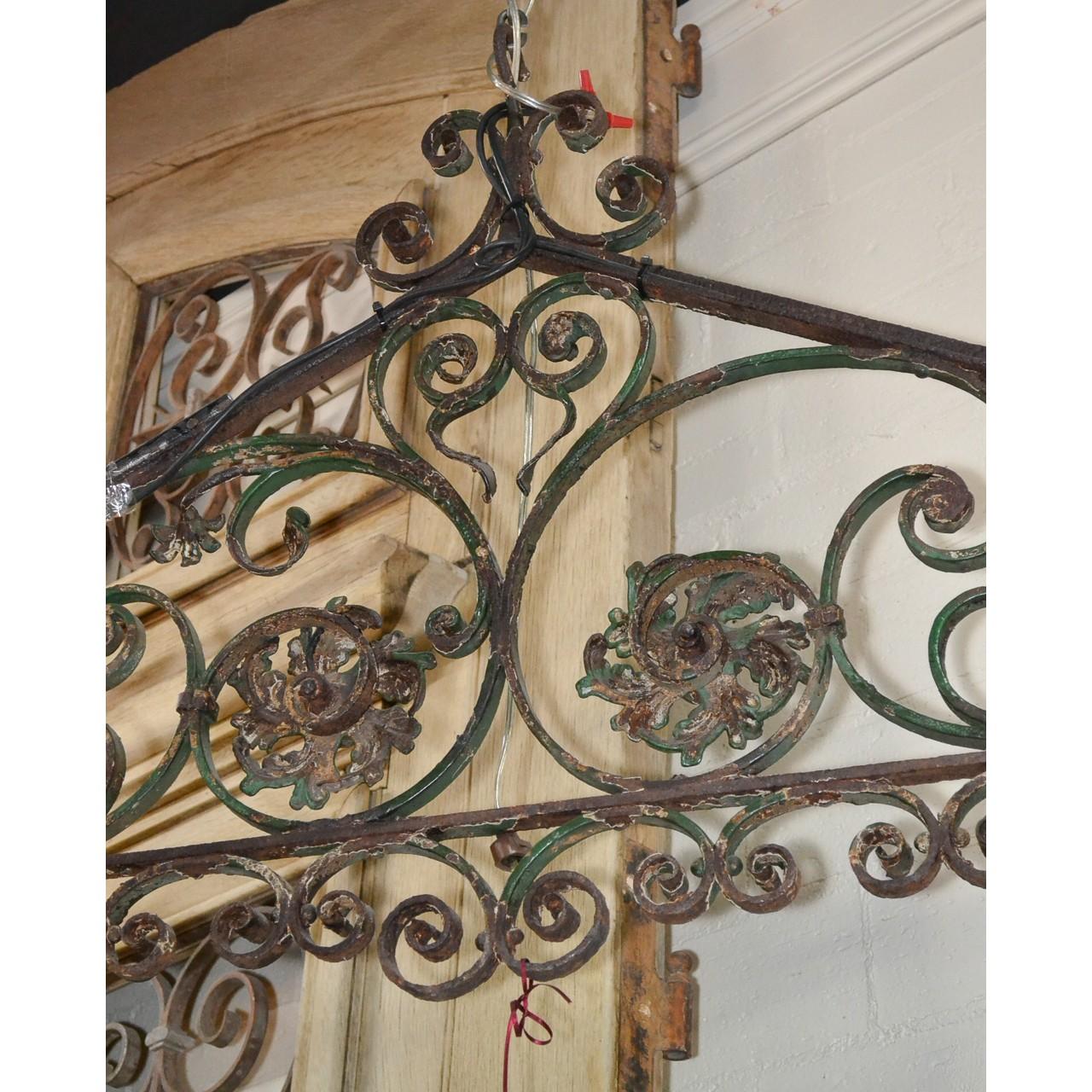 Unique 19th century French architectural handwrought iron light fixture. Triangular in shape and ornately scrolled and contoured with two dome-shaped and ribbed shades,

circa 1870.