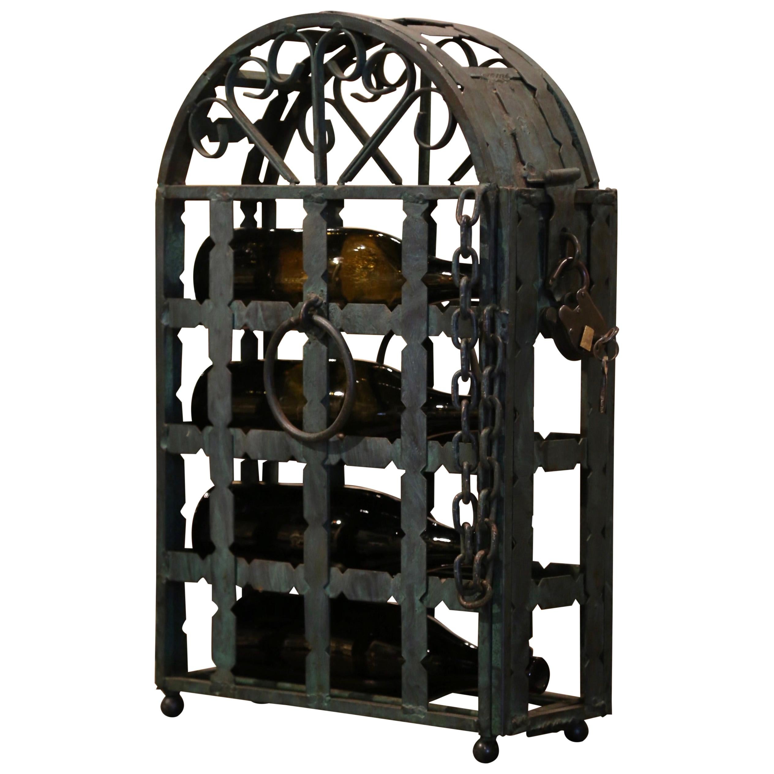 Decorate a wine cellar or wet bar with this elegant antique bottle cabinet, created in France circa 1890, the wrought iron wine storage features an arched top with scrolled accents, hinged door with chain support and lock mechanism to one side, and