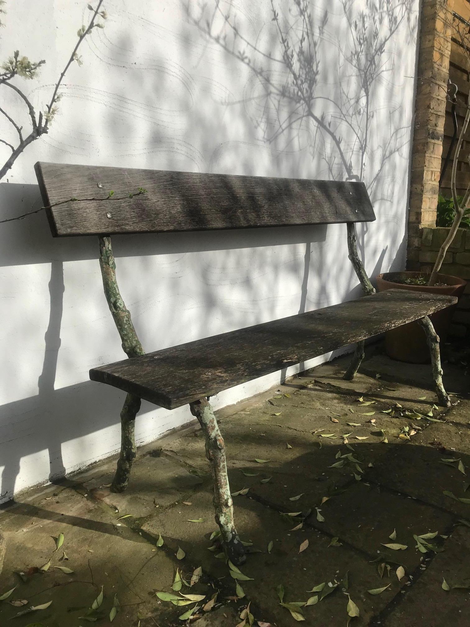 A late 19th century French fabulous green faux branch wrought iron bench with oak blank seat and back. (Oak replaced but nicely weathered).