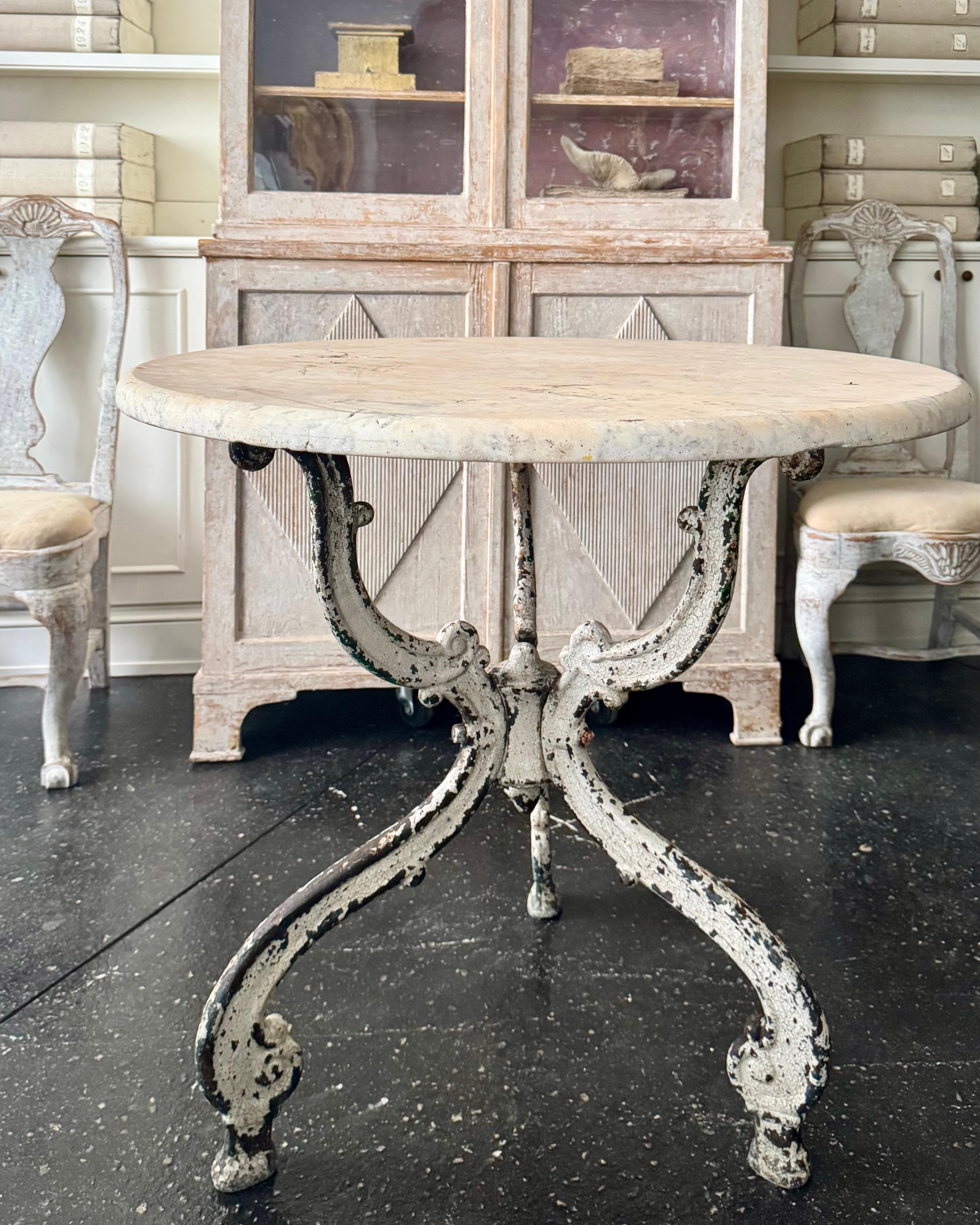 19th century French garden center table with thick round antique marble top supported by three leg solid iron base.
The iron has aged rusty patina with old paint remnants.
The thick marble top has rounded edge with a small old chip - adding a little