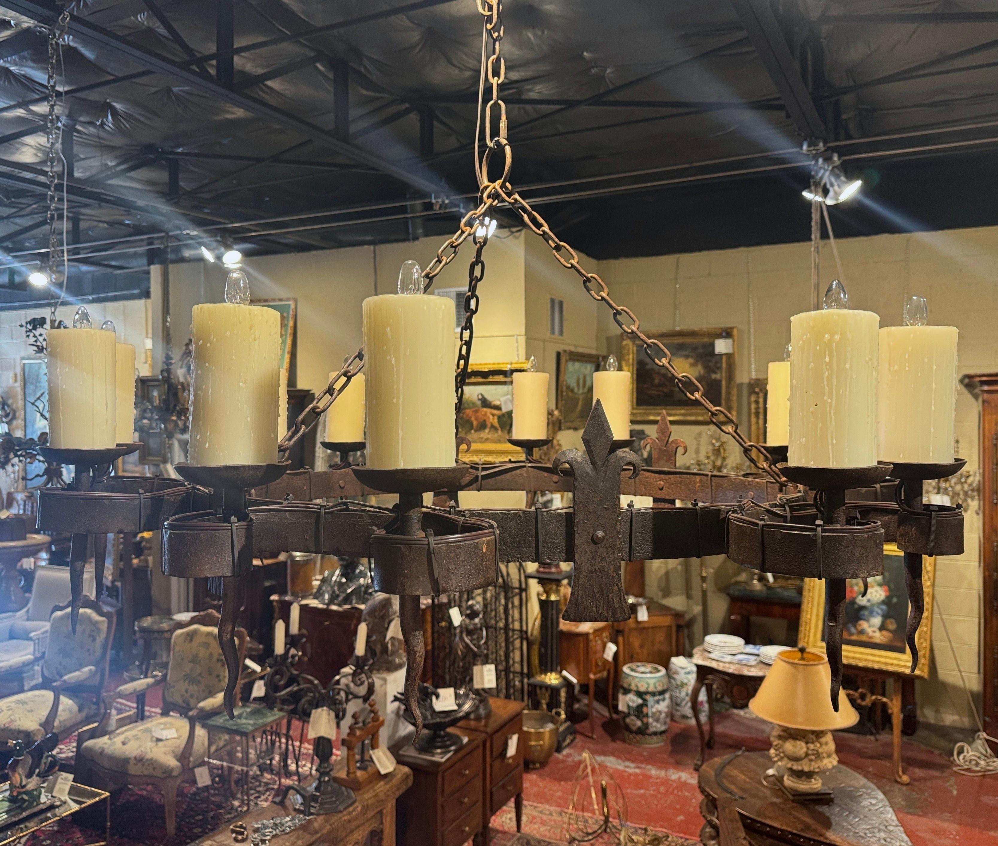 Posiziona questa grande lampada antica sopra un tavolo da pranzo o in una sala da pranzo. Forgiato in Francia, in Normandia, intorno al 1880, e con un diametro di quasi un metro e mezzo, il grande lampadario costruito in solido ferro battuto