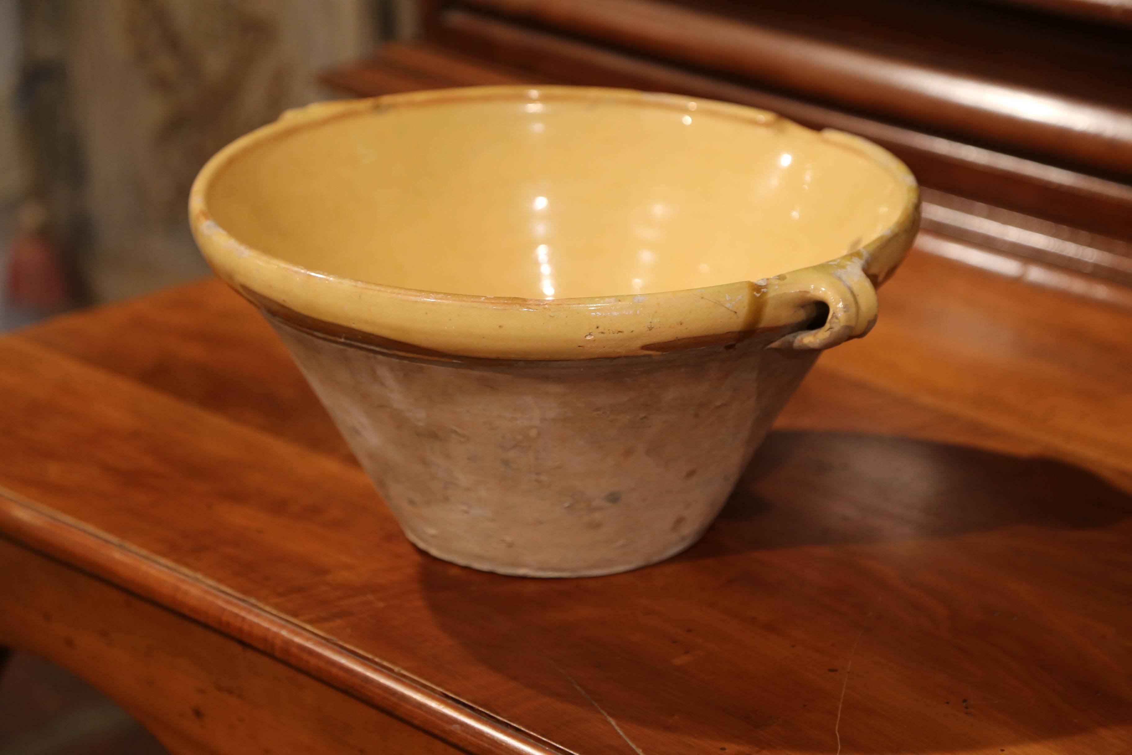 Beautiful antique Tian (Provencal term for bowl) from southern France; crafted in Provence, circa 1870, this round handmade terracotta bowl features two small handles, a server beak, and has a subtle yellow glaze on the inside with natural