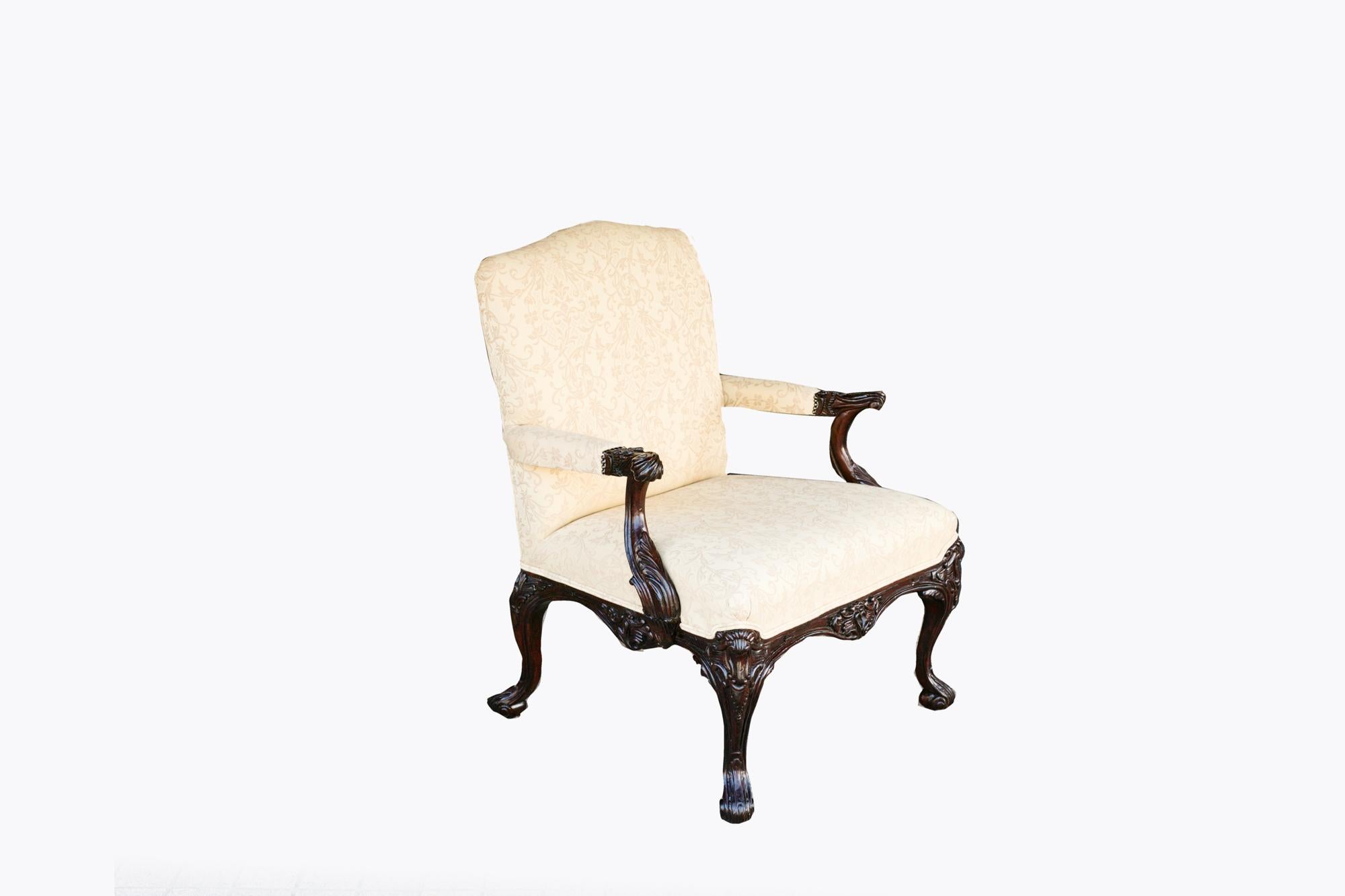 19th Century Gainsborough chair with profusely carved ebonised wood frame featuring foliate motifs and cabriole legs. 