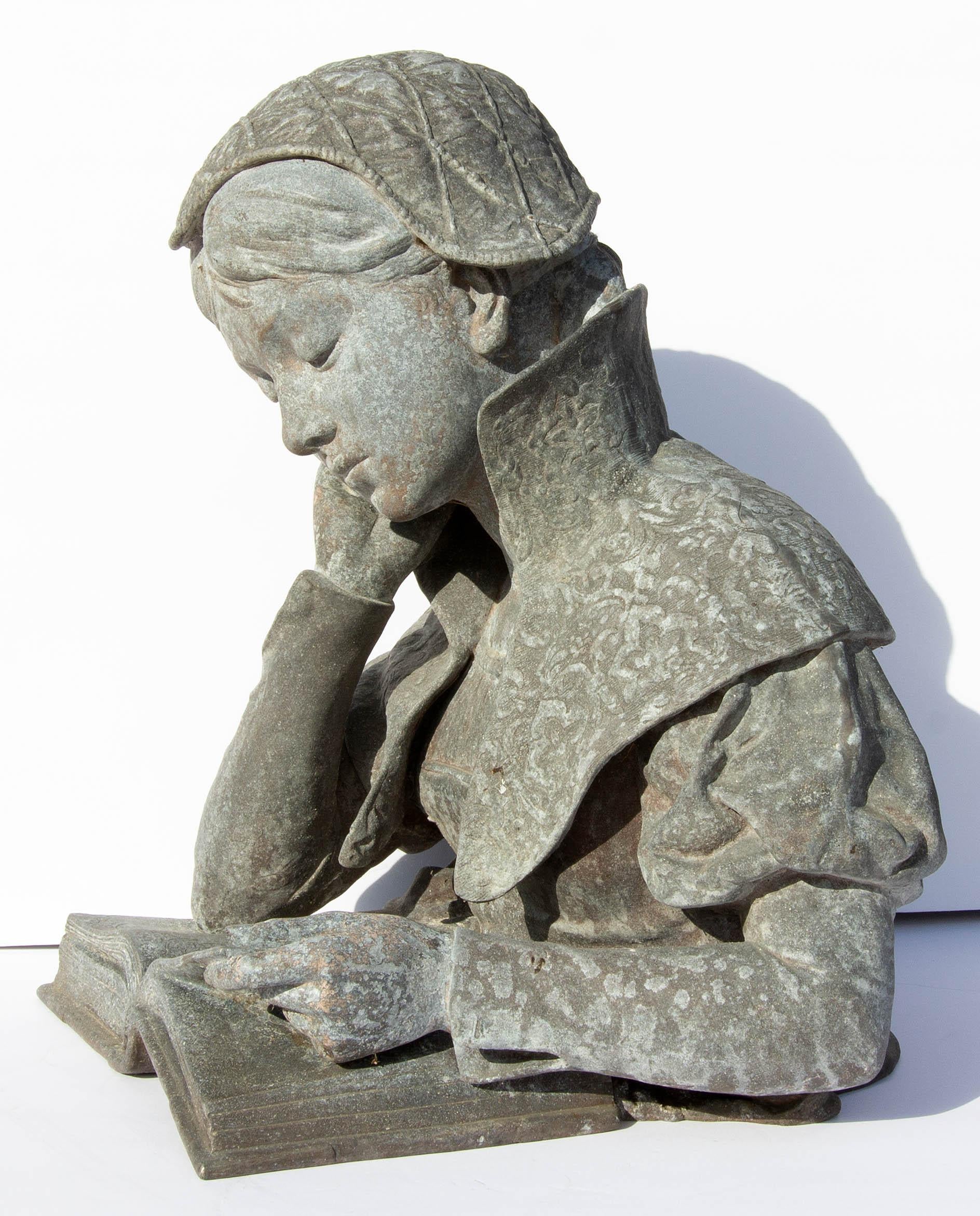 Antique zinc garden sculpture. Young girl reading illuminated French manuscript, 19th century.