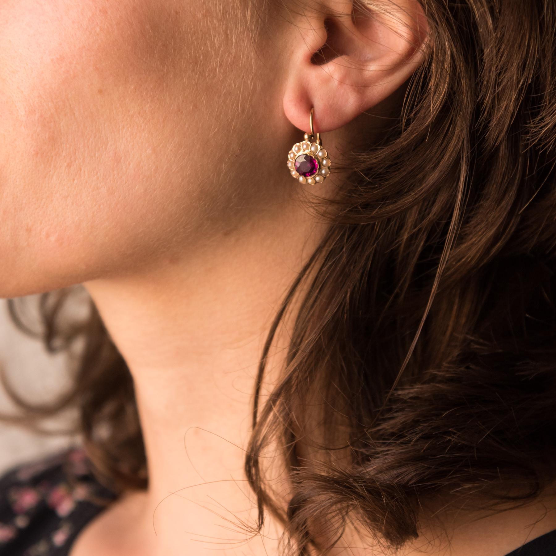 Earrings in 18 karats rose gold, owl hallmark.
Bright and refined, each earring is closed set in the center of a faceted garnet surrounded by natural semi-pearls. The clasp sneaks from the back.
Total weight of garnets: approximately 1.60