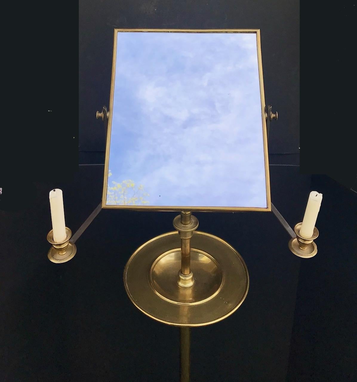 This gentleman's English Campaign shaving stand and mirror is from the 19th century and barely shows any wear. It is freestanding and the mirror adjusts to move up and down telescopically. Attached are a brass bowl and a moving candle holder on each