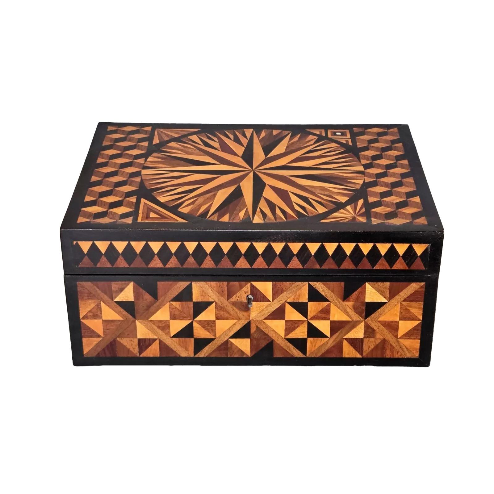 Regency jewelry or dresser box with an interior divided mahogany tray. The exterior with exotic wood inlaid in various geometric patterns within ebony borders. The lid with two panels of tumbling block centering a large central sunburst with a