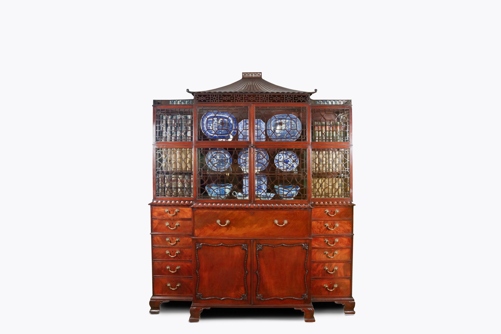 19th Century George III Chinese Chippendale breakfront display cabinet. The carved central pagoda sits over a glazed top with an open fretwork band to the upper section. The lower section with moulded frieze above secretaire drawer sits above a pair