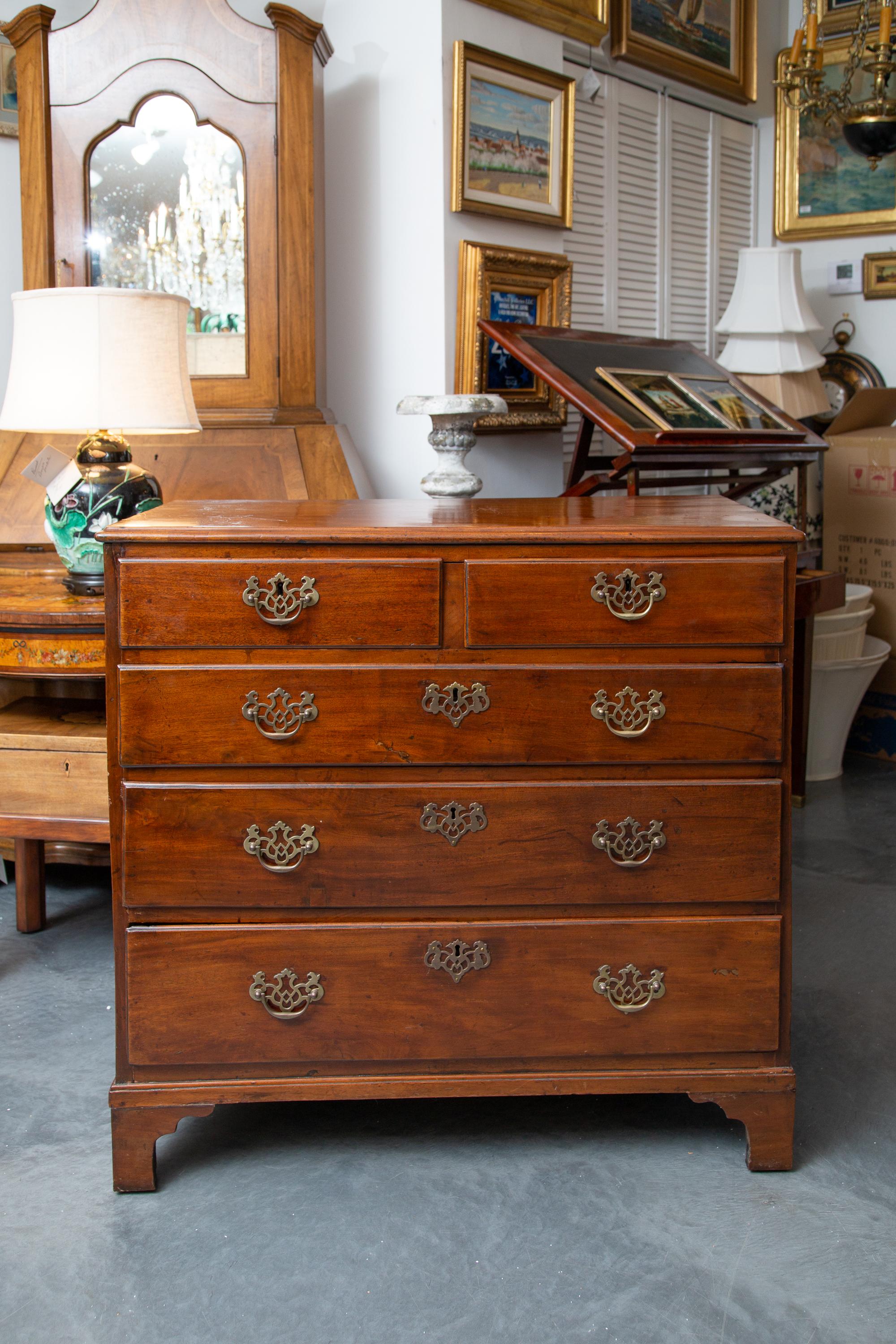 This is a very mellow English George III mahogany chest of drawers, the top with molded edge above two short and three long graduated drawers situated on base with shaped bracket feet, early 19th century.