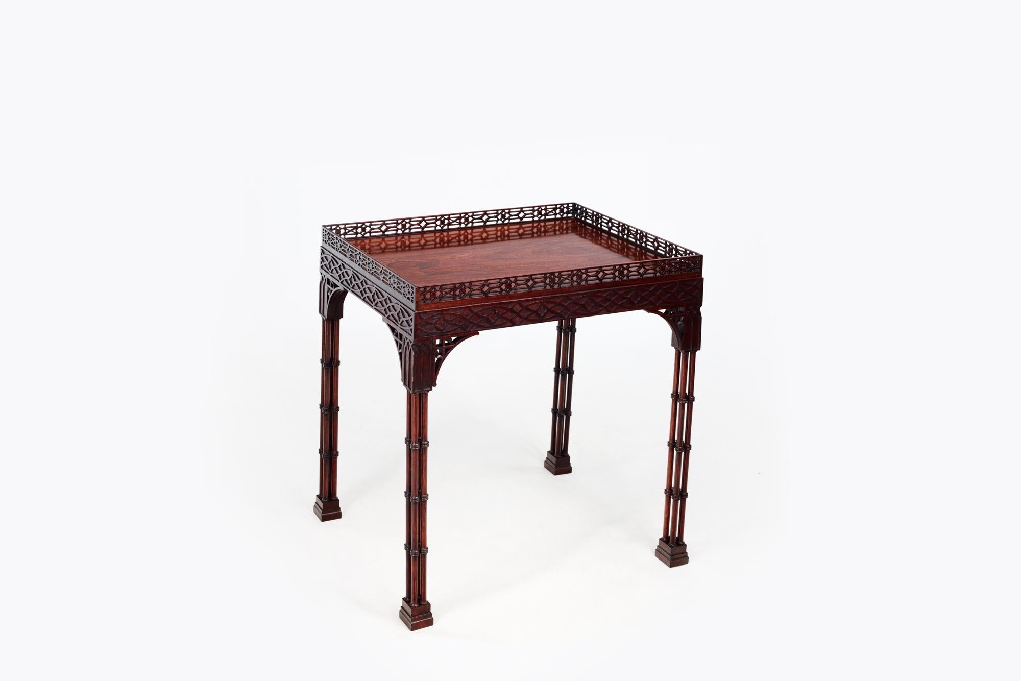 Mahagoni-Silbertisch aus dem 19. Jahrhundert im chinesischen Chippendale-Stil. Die durchbrochenen Eckkonsolen tragen ungewöhnliche Säulenbeine und enden auf Blockfüßen. Die rechteckige Platte ist an allen vier Seiten mit einem blinden Laubsägefries