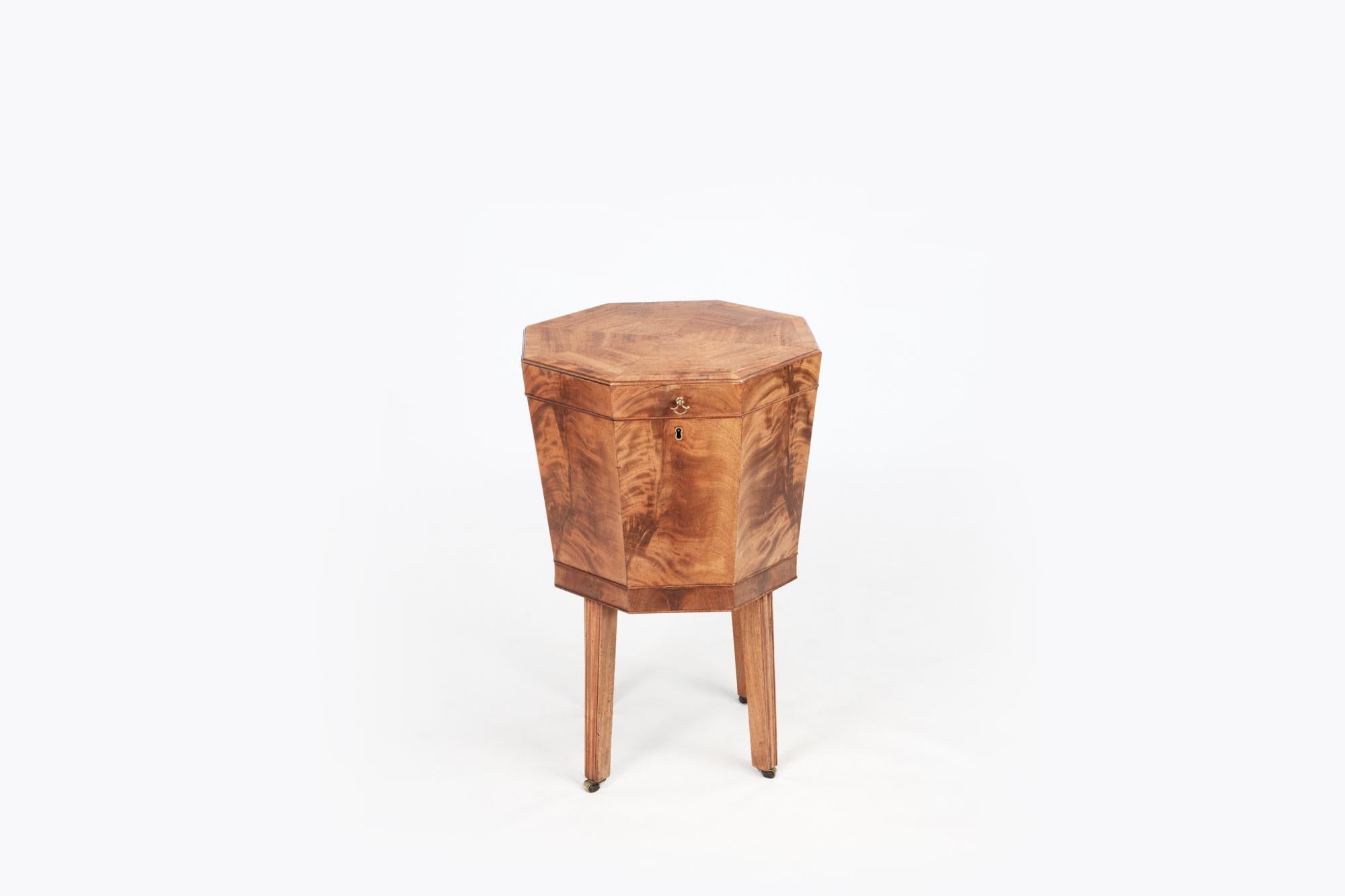 19th Century George III Mahogany octagonal cellarette. The tapering body with simple moldings stands on four tapering square legs terminating on simple brass castors. The piece is complete with a lead-lined and fitted interior.