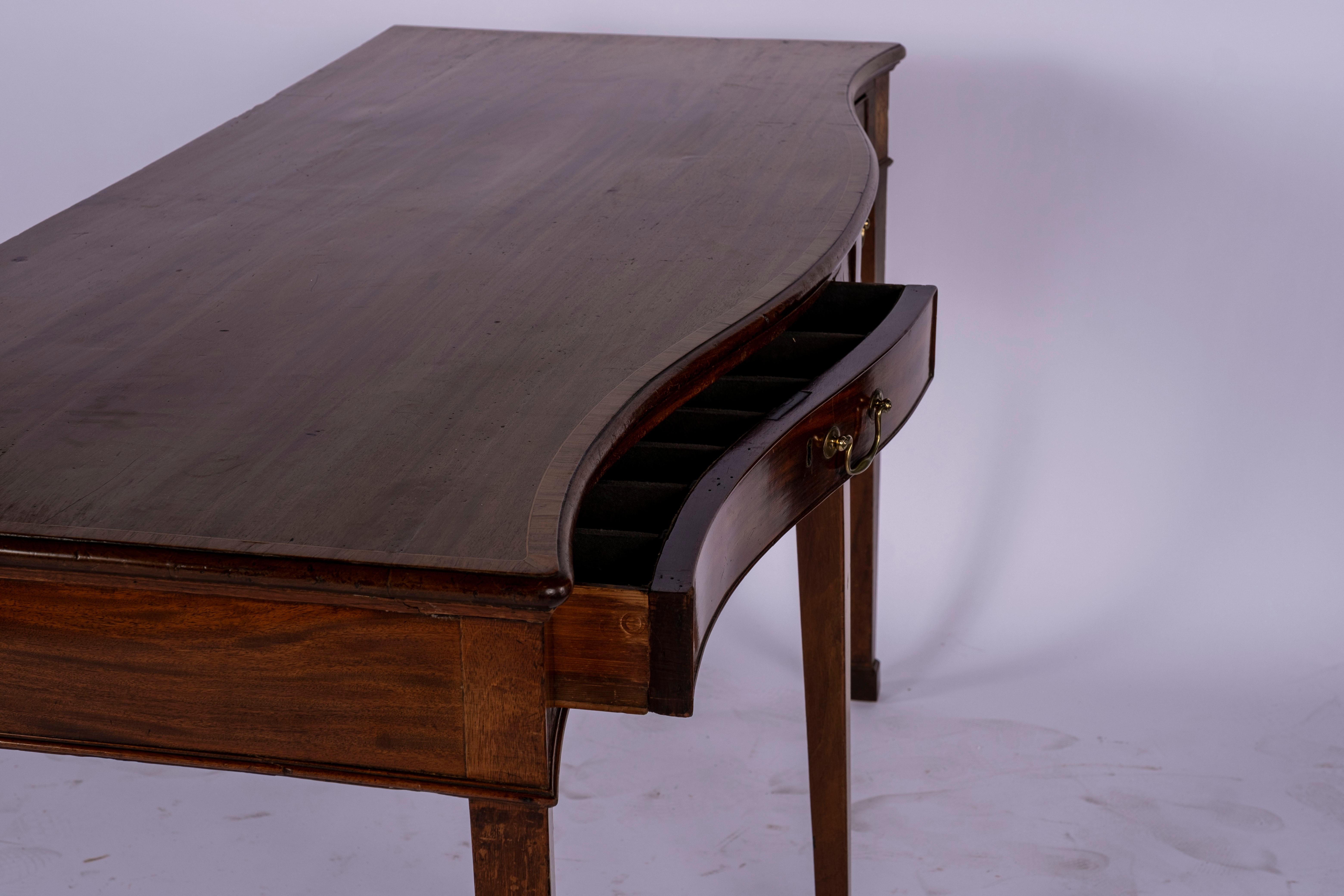 Inlaid mahogany George III serpentine front huntboard with two drawers fitted for flatware with silver cloth. Detailed with Conch shell and banded inlay on squared tapered legs ending in spade feet. Burn marks on top, split on either side of conch