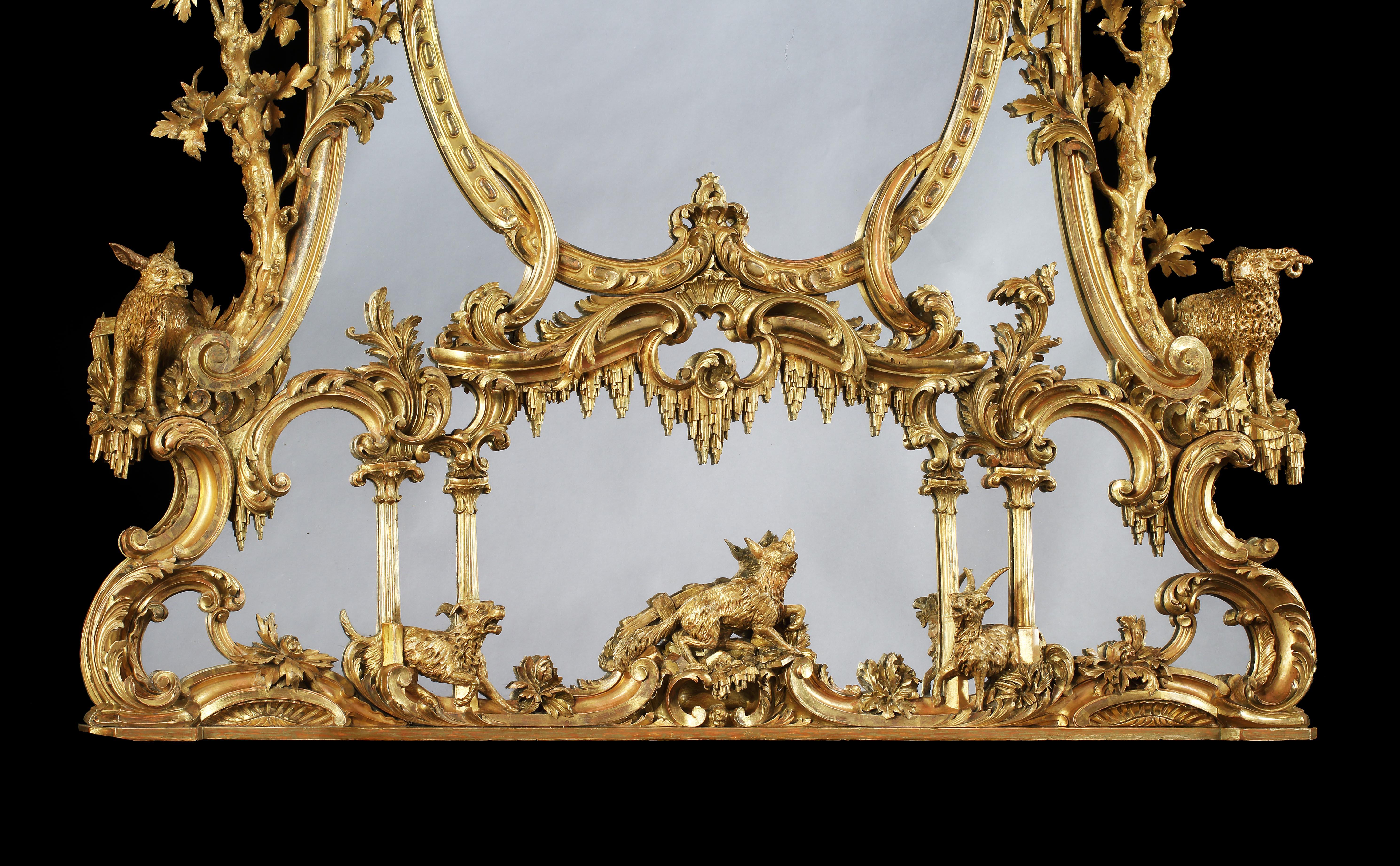 A George III style carved giltwood mirror
After a design by Thomas Johnson

Of grandiose proportions, the central oval glass plate built up in a concentric arrangement of mercury plates surrounded by an ornately carved giltwood frame