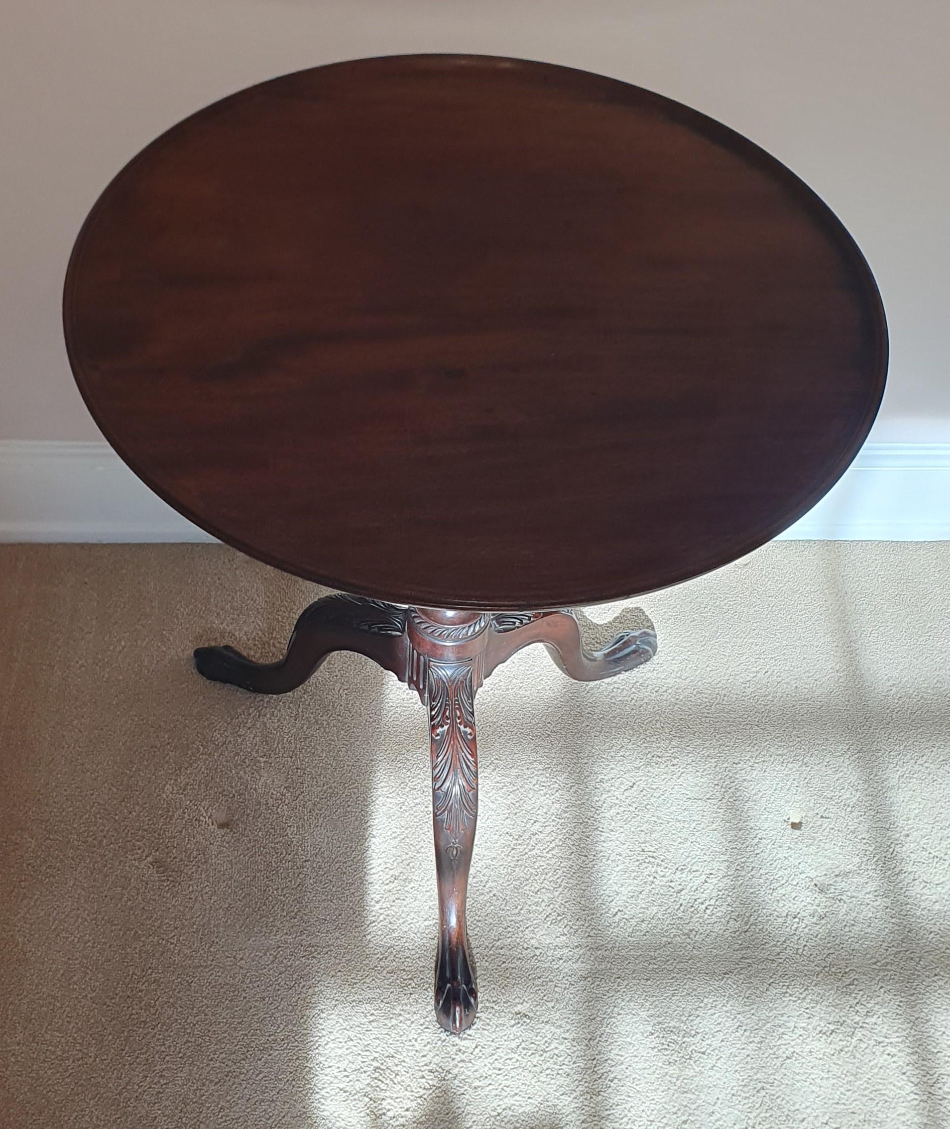 Offering an exceptionally good condition 19th Century solid Mahogany occasional table in the George III Style. This table features and beautifully carved pedestal base with a flip top with original cast brass switch latch and hinge mechanism - very